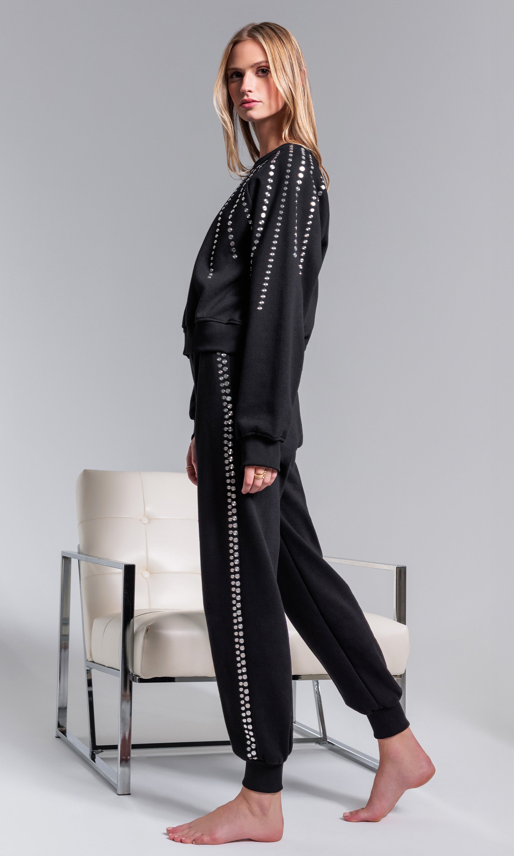 Person wearing a black outfit with white patterns on a gray background