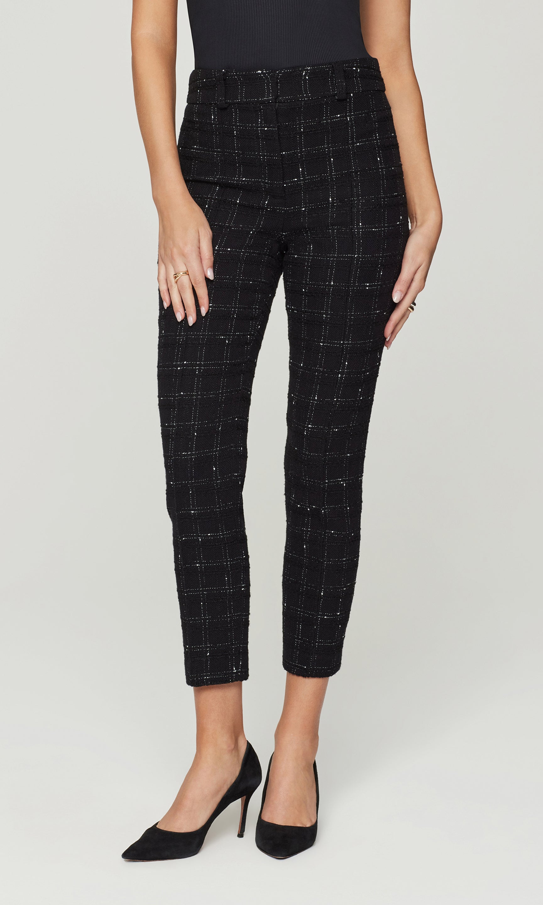Person wearing black checkered pants on a white background
