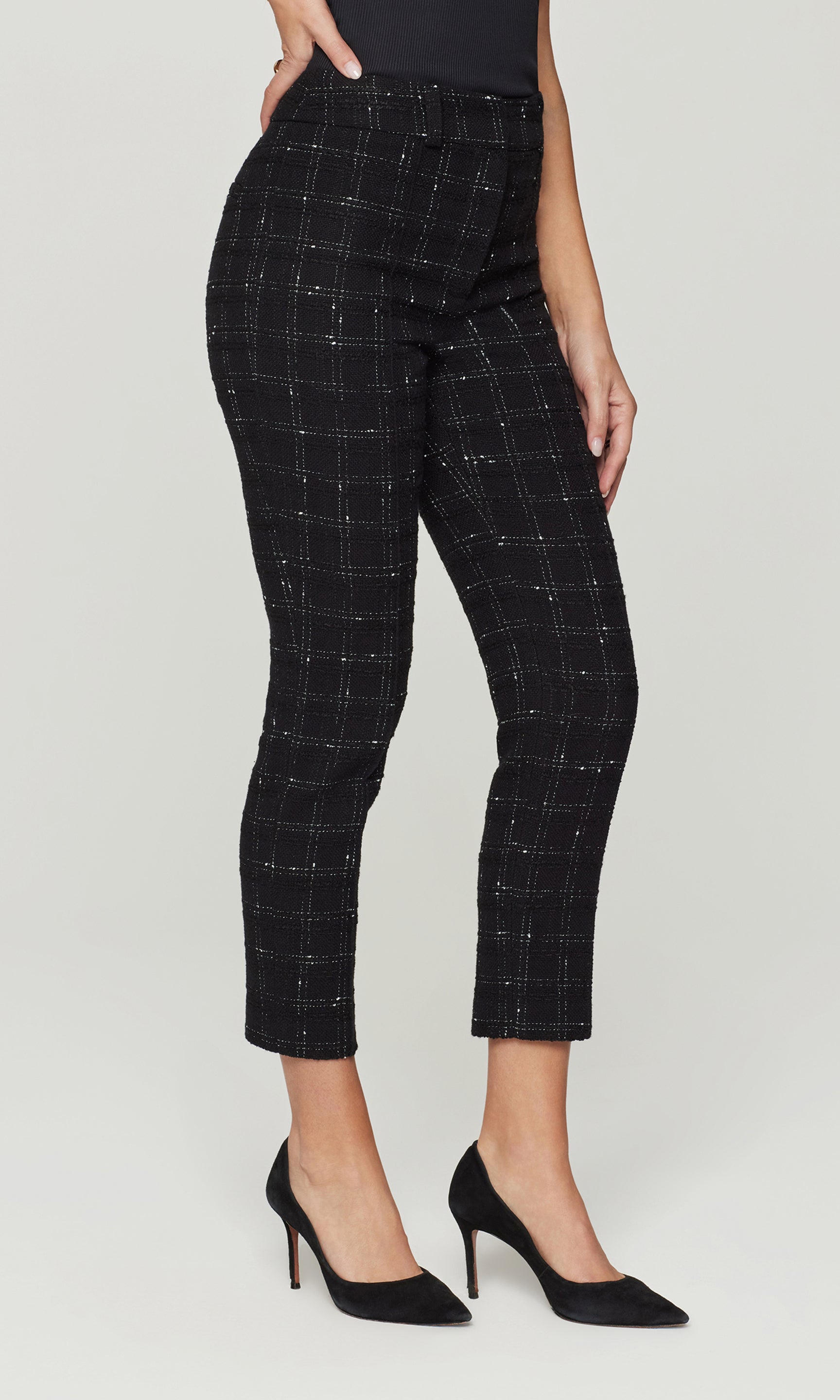 Side view of black checkered pants worn by a person on a white background