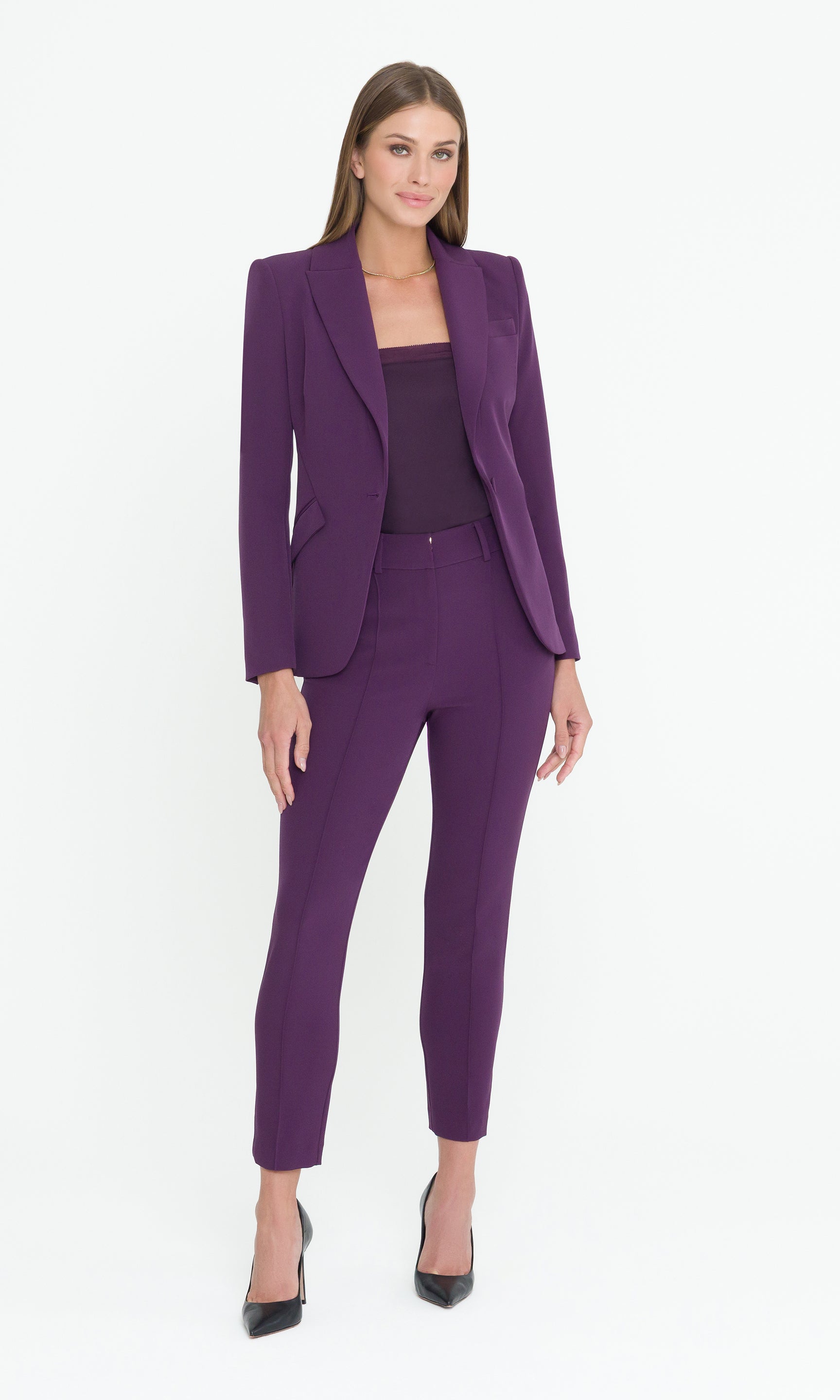 Full body image of model wearing a purple suit with purple cami on a white background