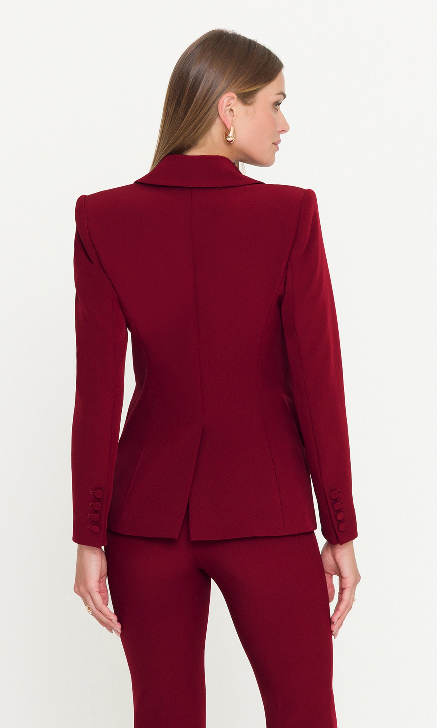 Back view of woman wearing a red suit on a white background