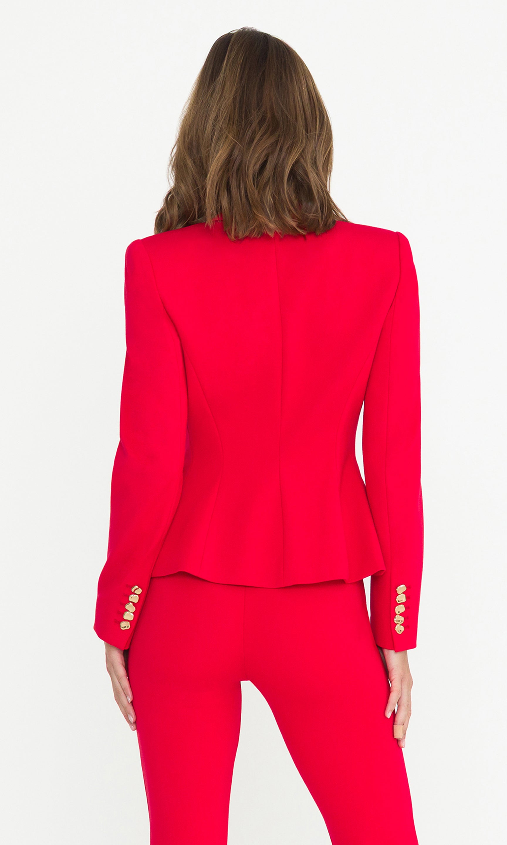 Back view image of model wearing a red blazer and matching trousers on a white background