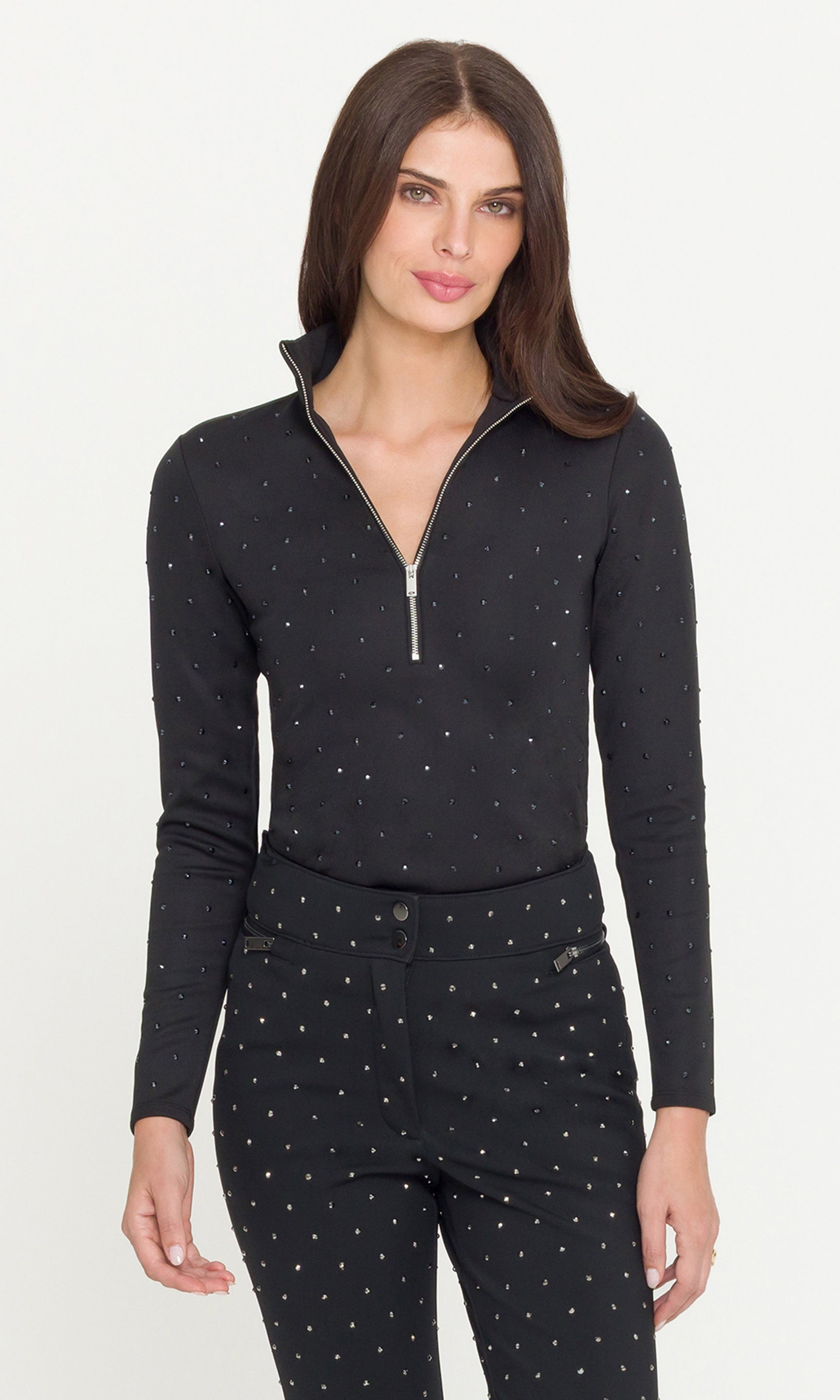 Woman wearing a black long-sleeve top with a quarter zip and matching pants on a white background