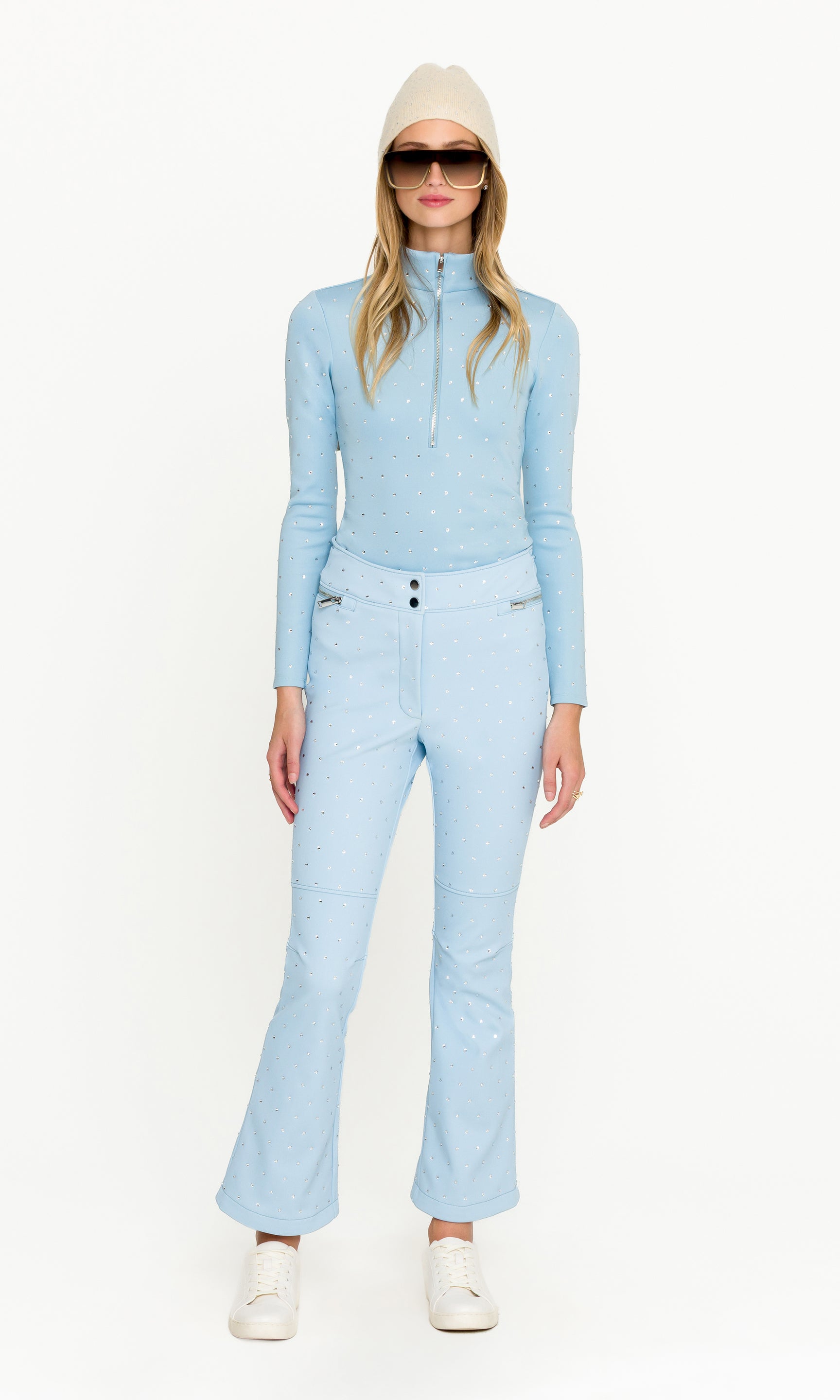 Woman wearing a light blue ski suit on a white background