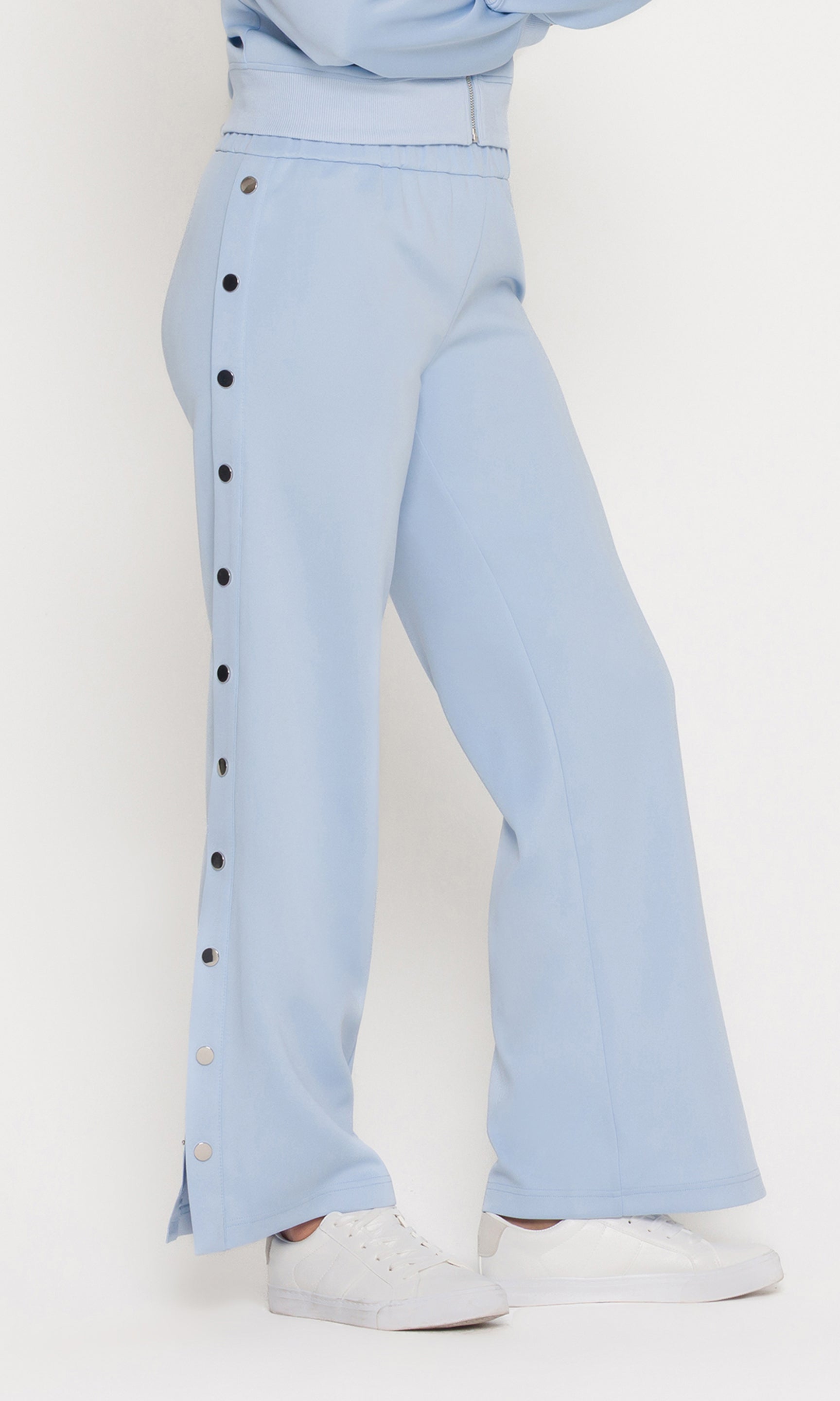 Side view of light blue pants with snap buttons on a white background