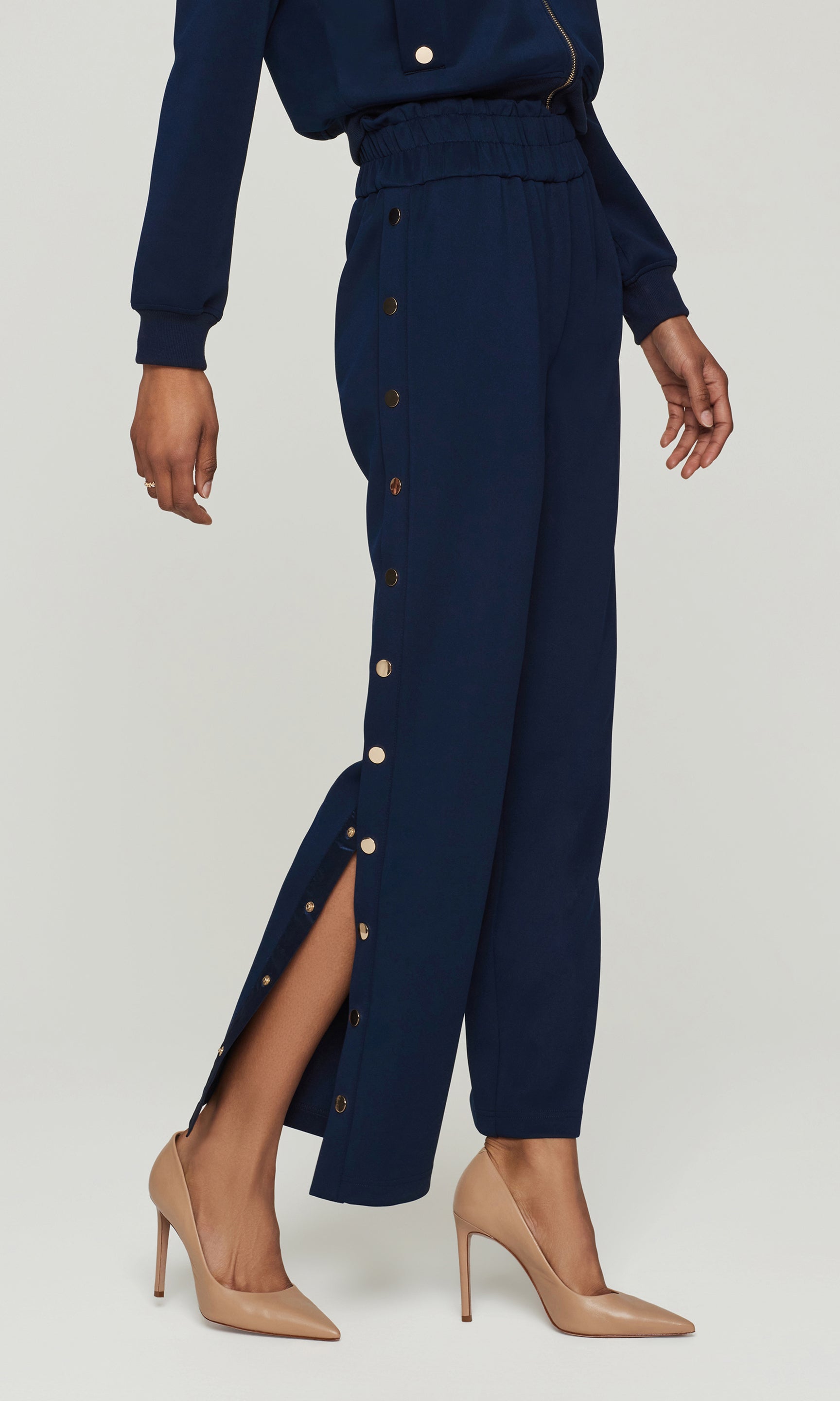 Navy blue pants with button details on a white background