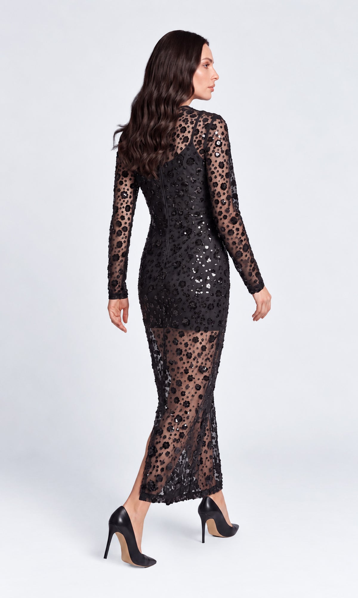 Back view of model wearing a long-sleeve black lace maxi dress with sequined floral detailing.