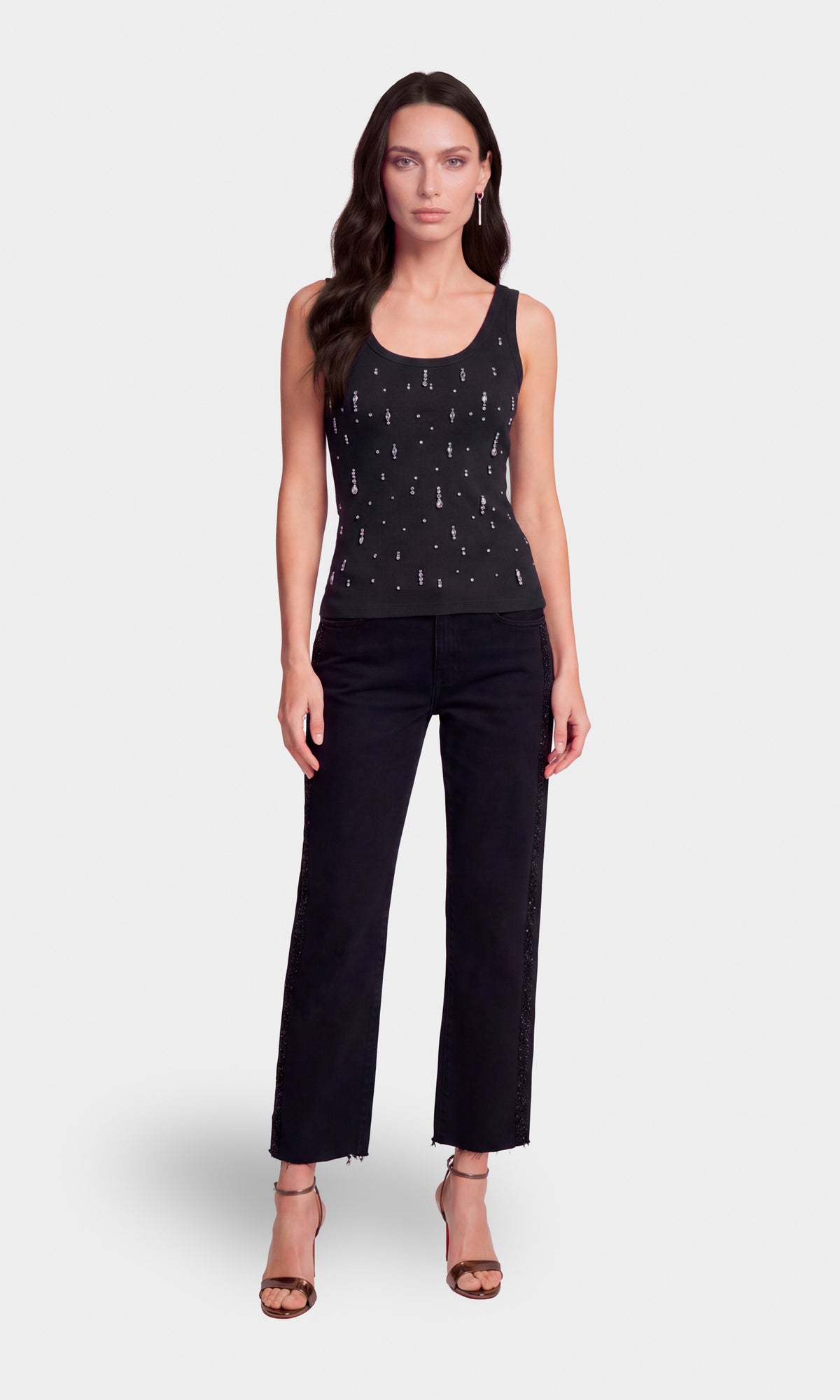 A woman modeling a black sleeveless tank top with small silver embellishments and black cropped pants.