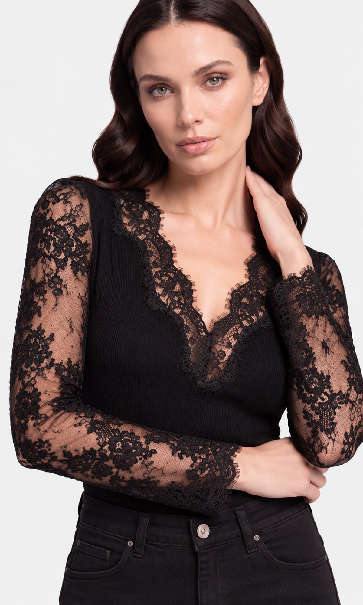 Close-up of a black long-sleeve lace top with a deep V-neckline and black jeans.