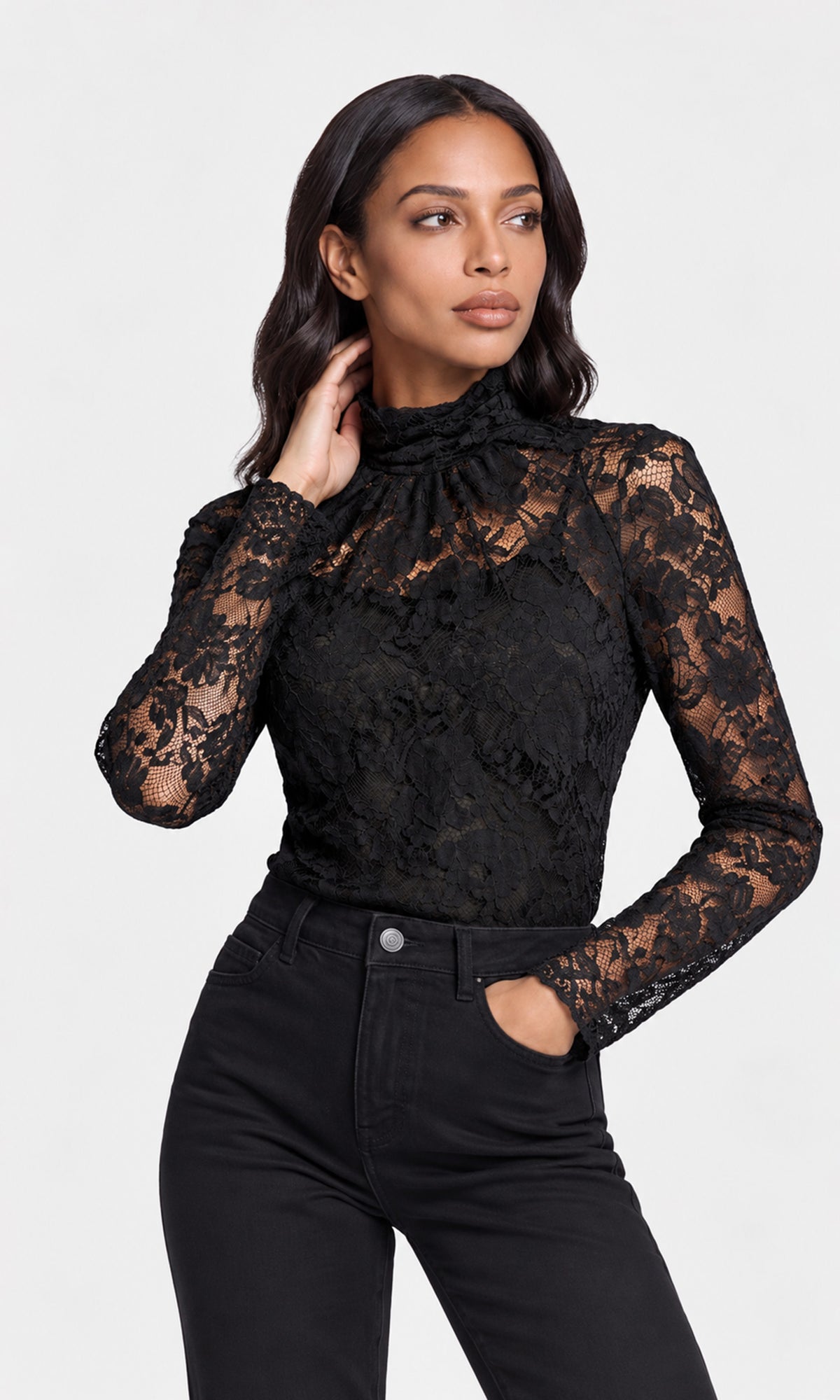 Model wearing a black lace, mock-neck op with black jeans.