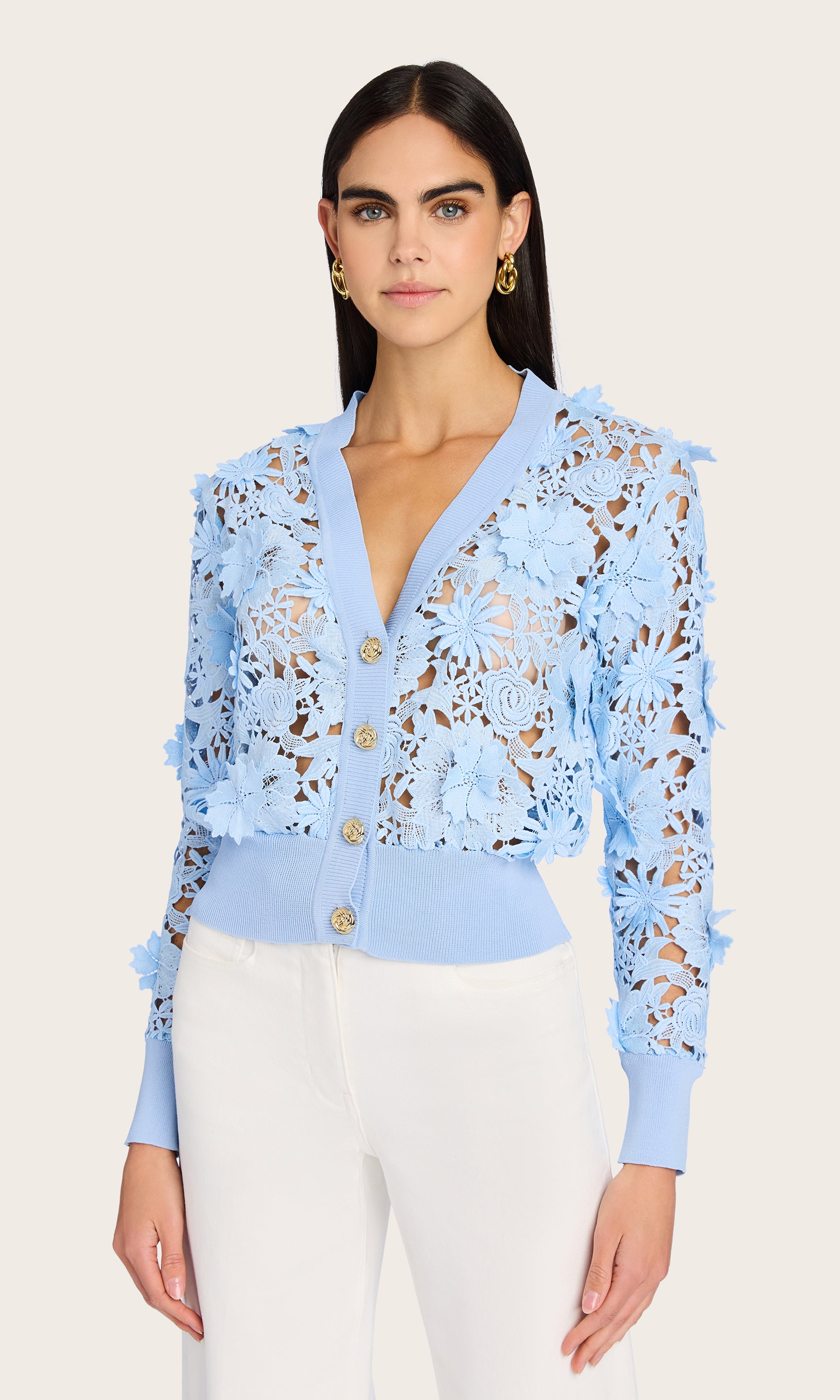 Front view of the Harlow Lace Cardigan styled on the model with white trousers, showcasing the V-neckline, gold-tone buttons, and scalloped lace edges.