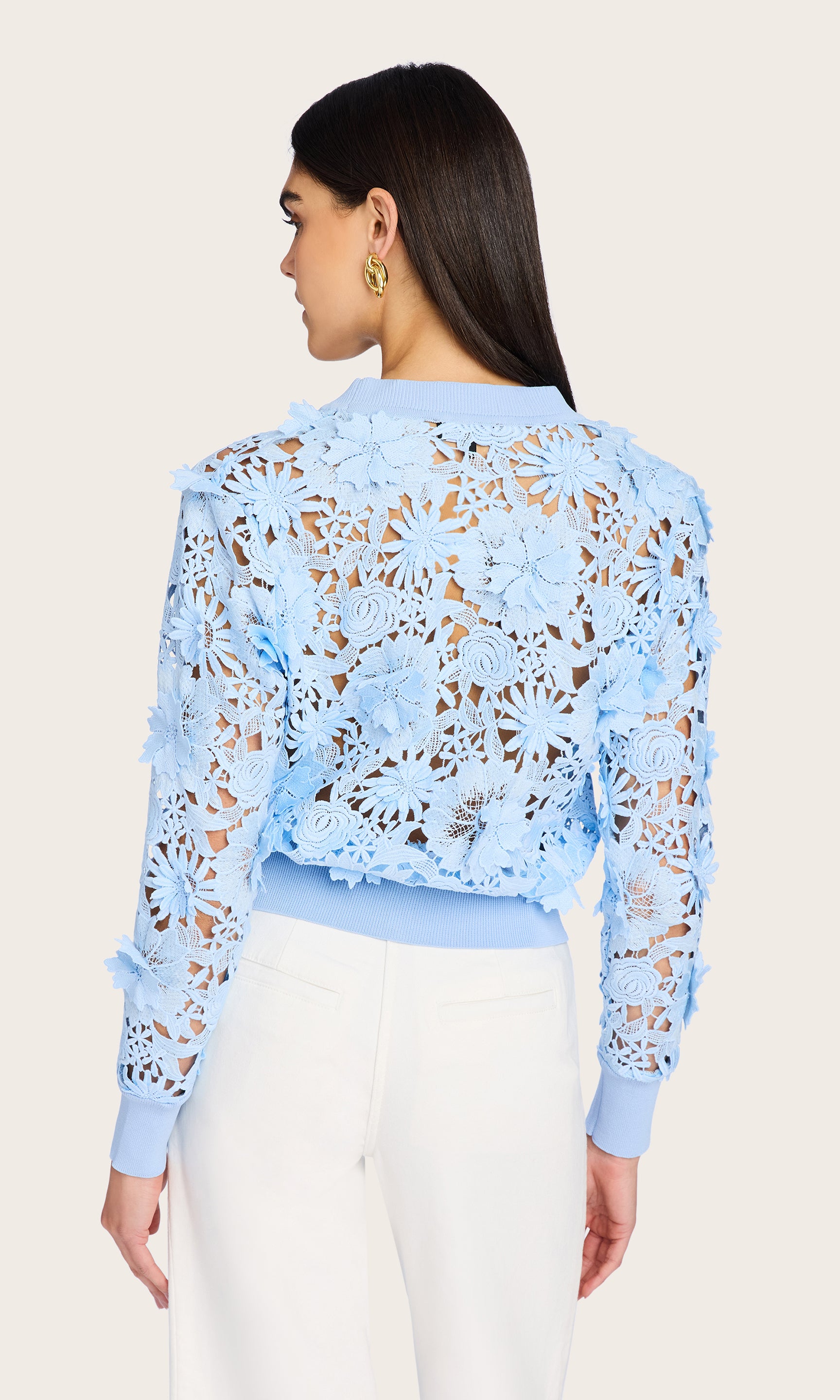 Rear view of the Harlow Lace Cardigan as worn by the model, highlighting the intricate floral lace pattern and soft pastel tone from behind.
