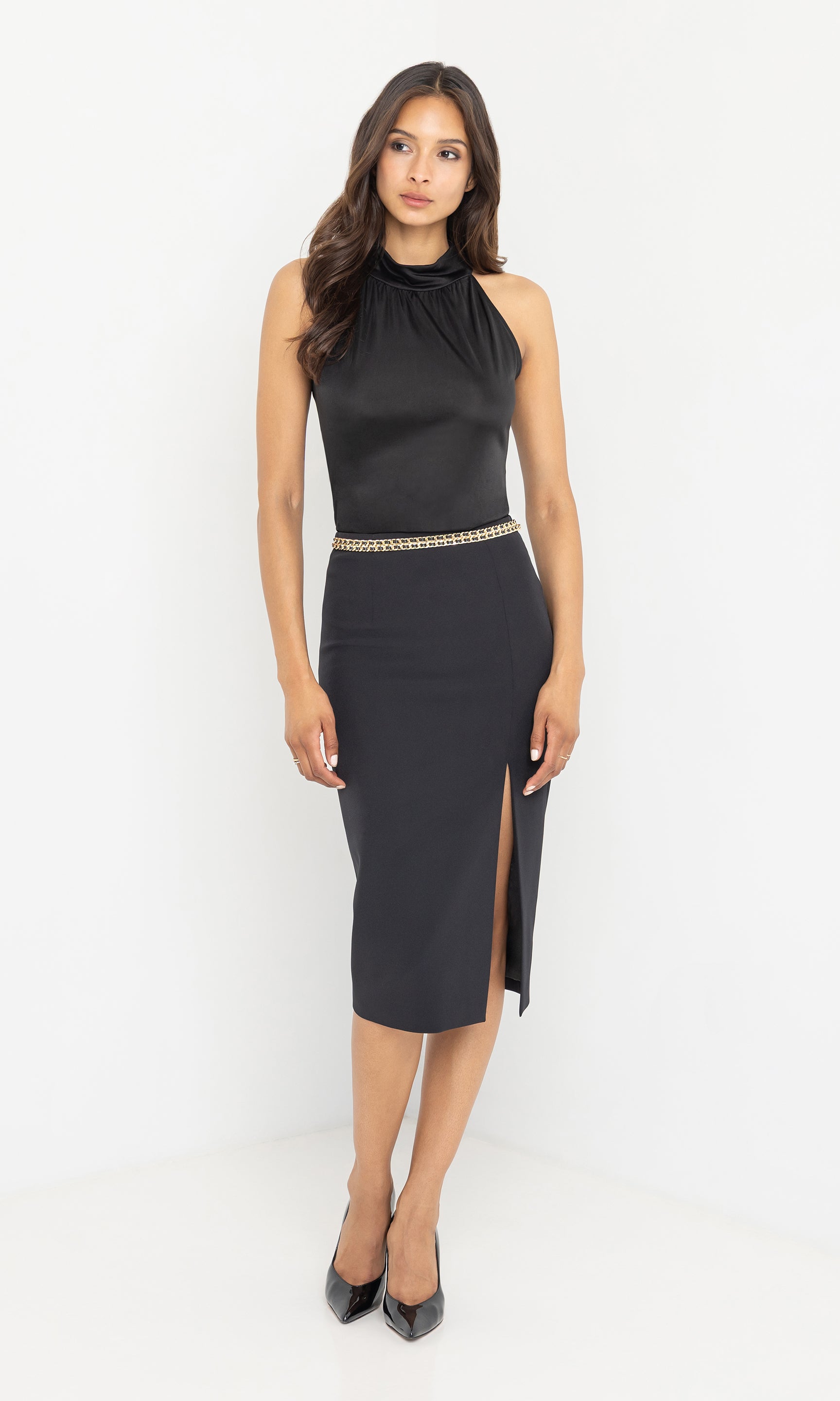 Full body angled view of the model in the margery crepe skirt styled with heels.