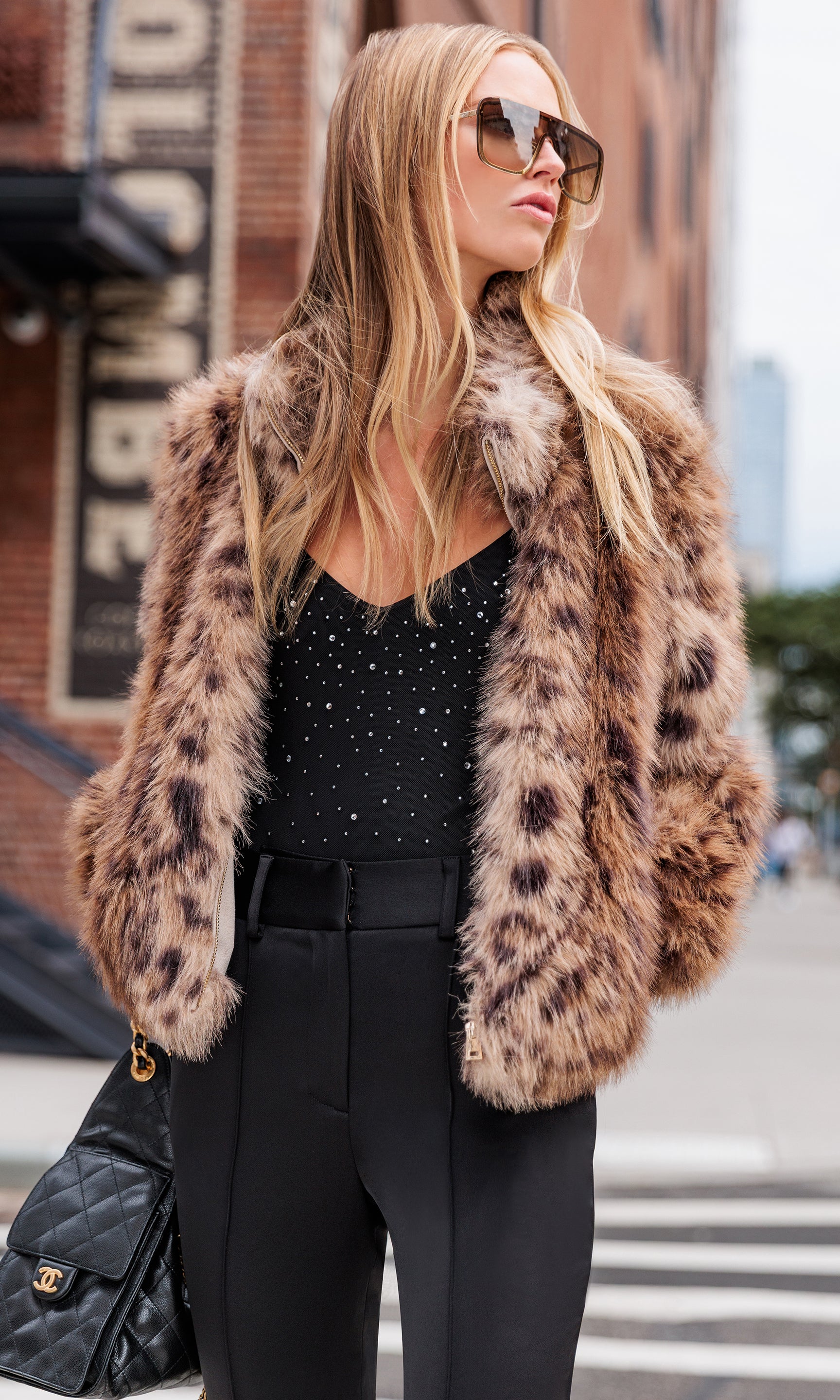 Woman wearing a leopard print fur coat in an urban setting