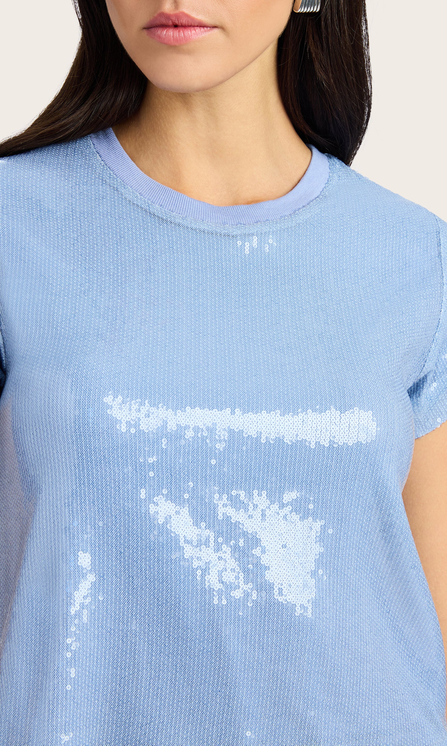 Close-up view showcasing the shimmer and crewneck detail of the Kai Sequin Top