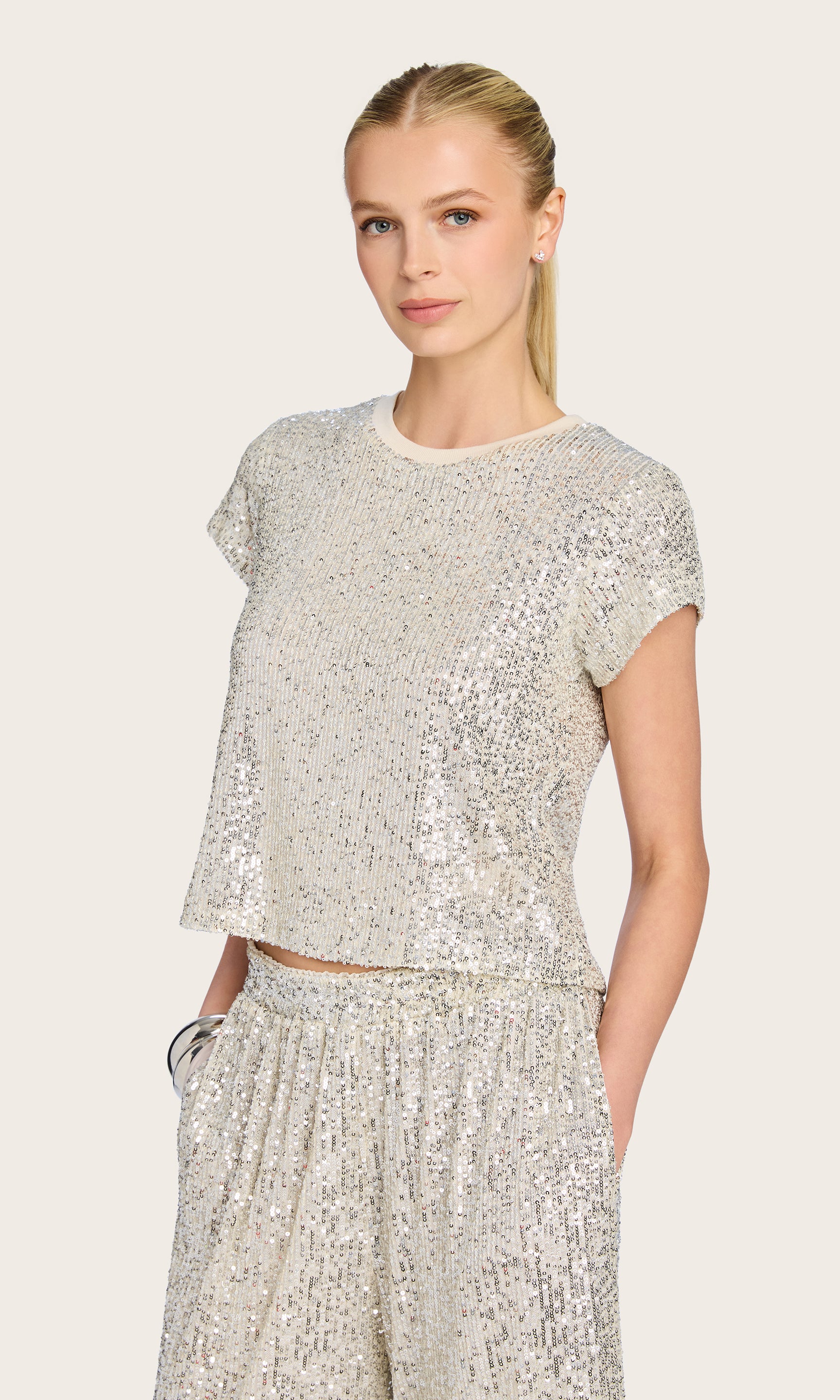 3/4 front view of model wears the Kai Sequin Top in silver, paired with matching sequin pants for a coordinated statement look.
