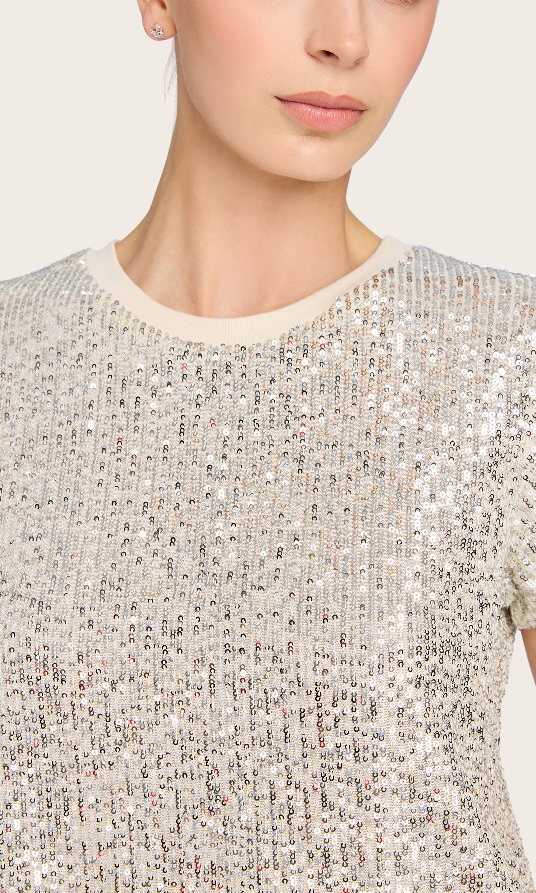 Close-up front view of the model in the Kai Sequin Top in silver, highlighting the soft crewneck and allover sequin texture.