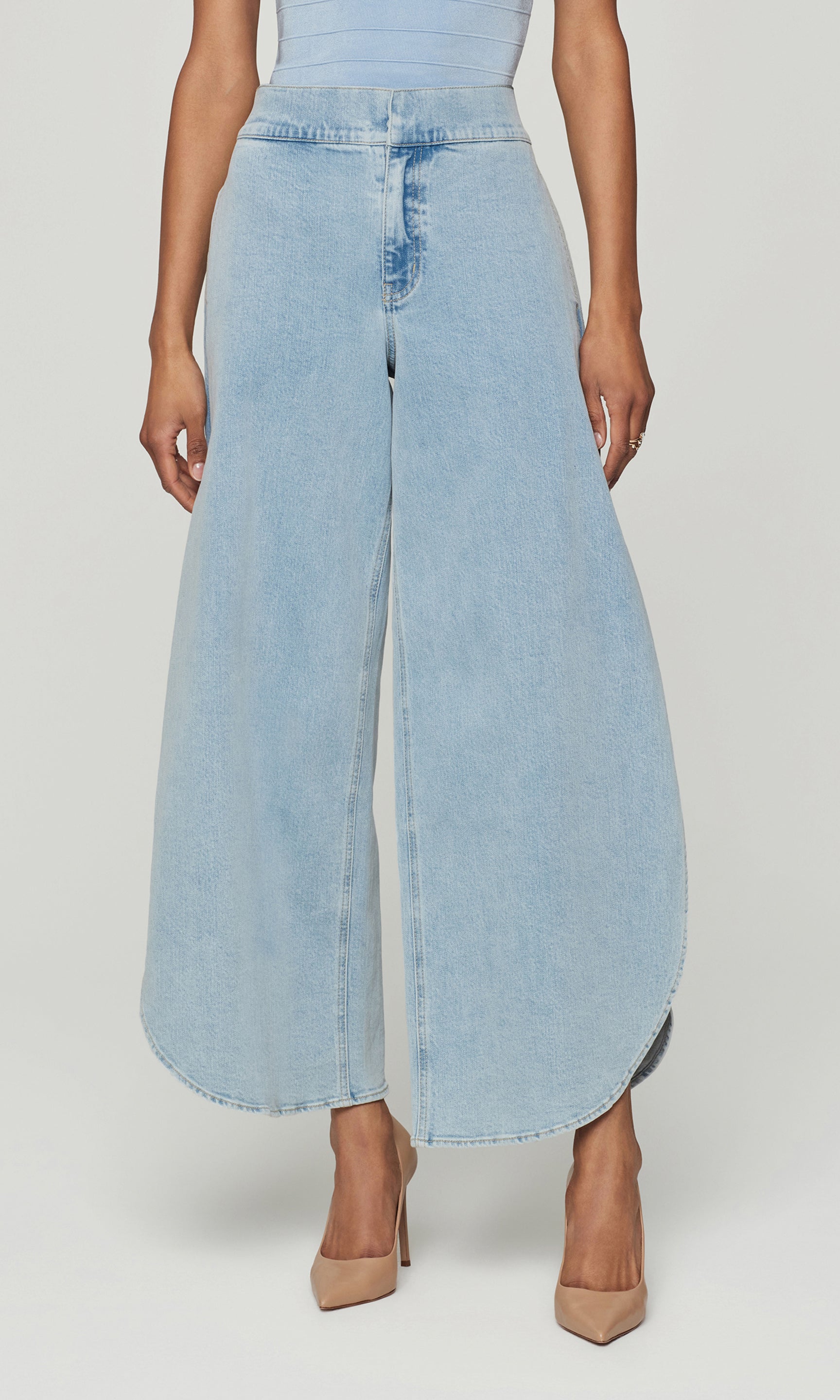 Light blue denim wide-leg pants worn by a person on a white background