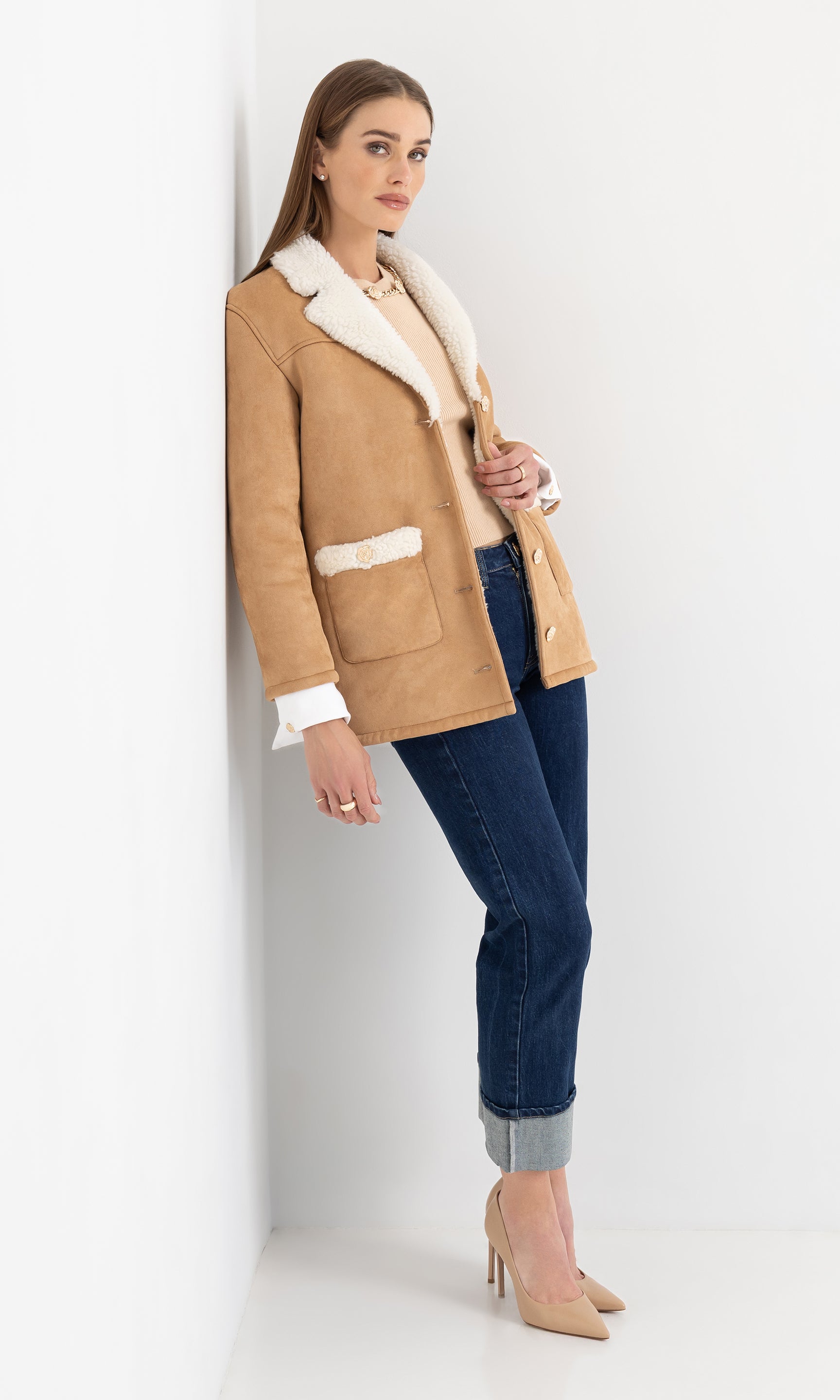 Full body front view of the model in the luvia faux shearling jacket styled with denim.