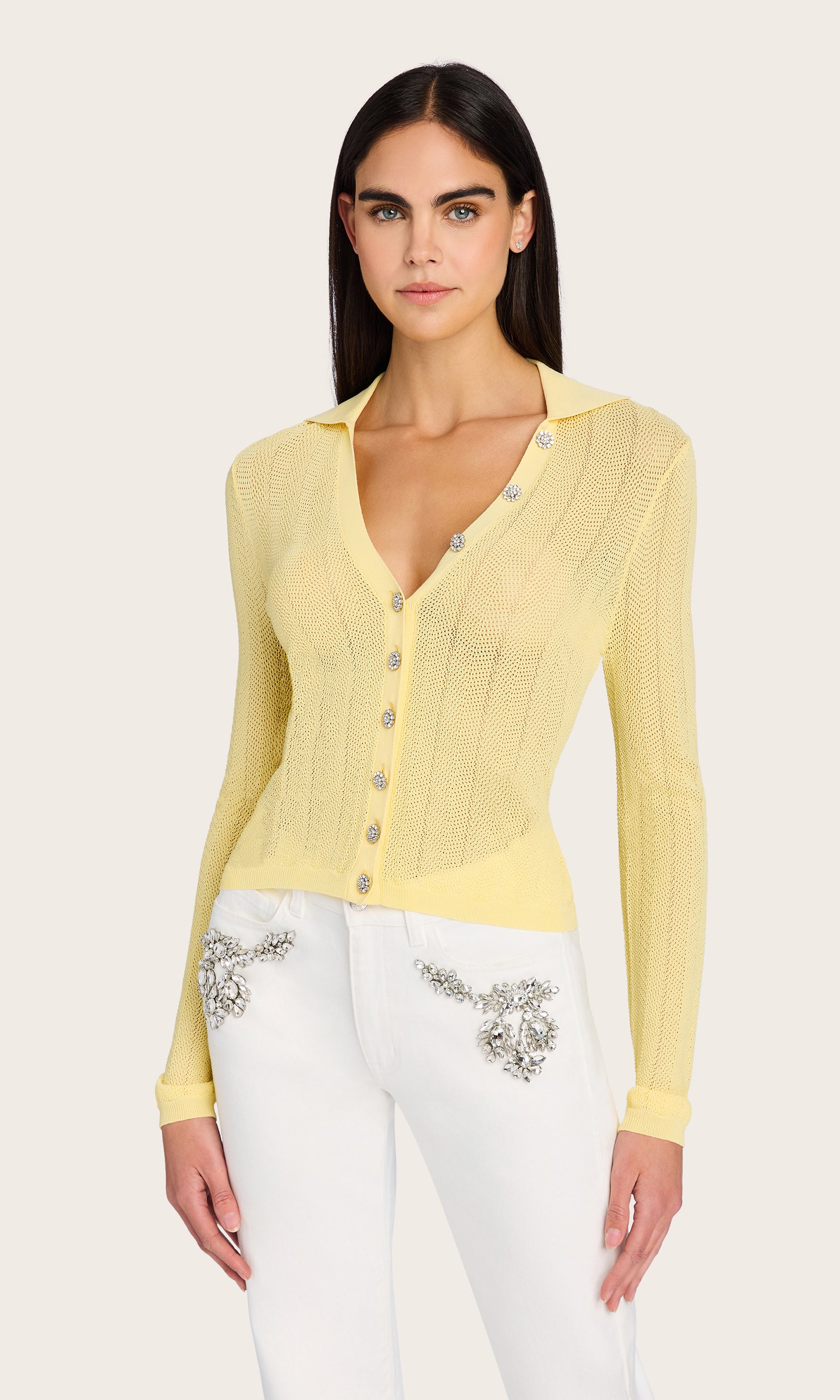 Front view of the model wearing the Megan Pointelle Cardigan, styled with white embellished pants to highlight its shimmer and slim fit.