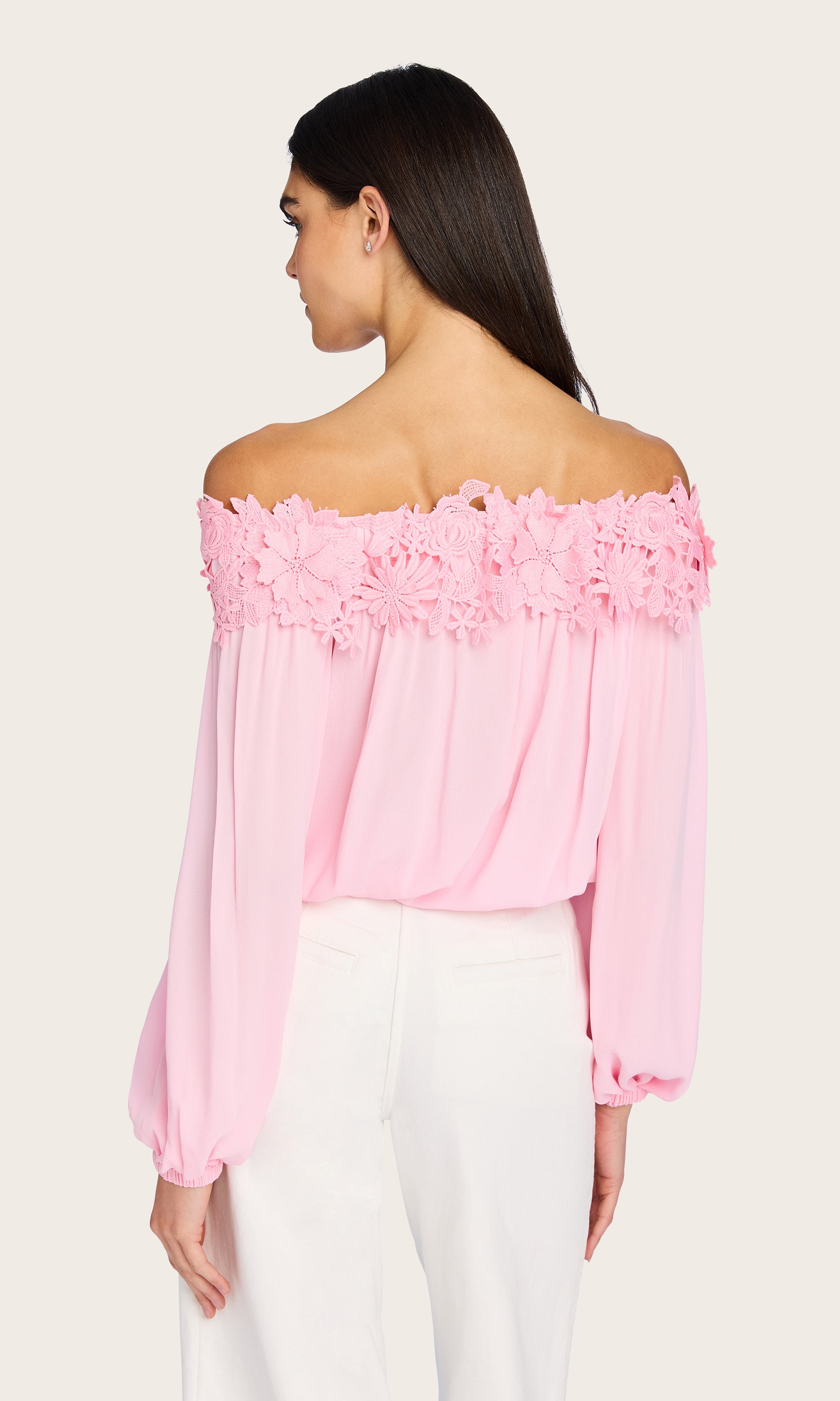 From the back, the model highlights the clean, straight hem and the gentle flow of the Merla Lace Combo Blouse’s relaxed fit.