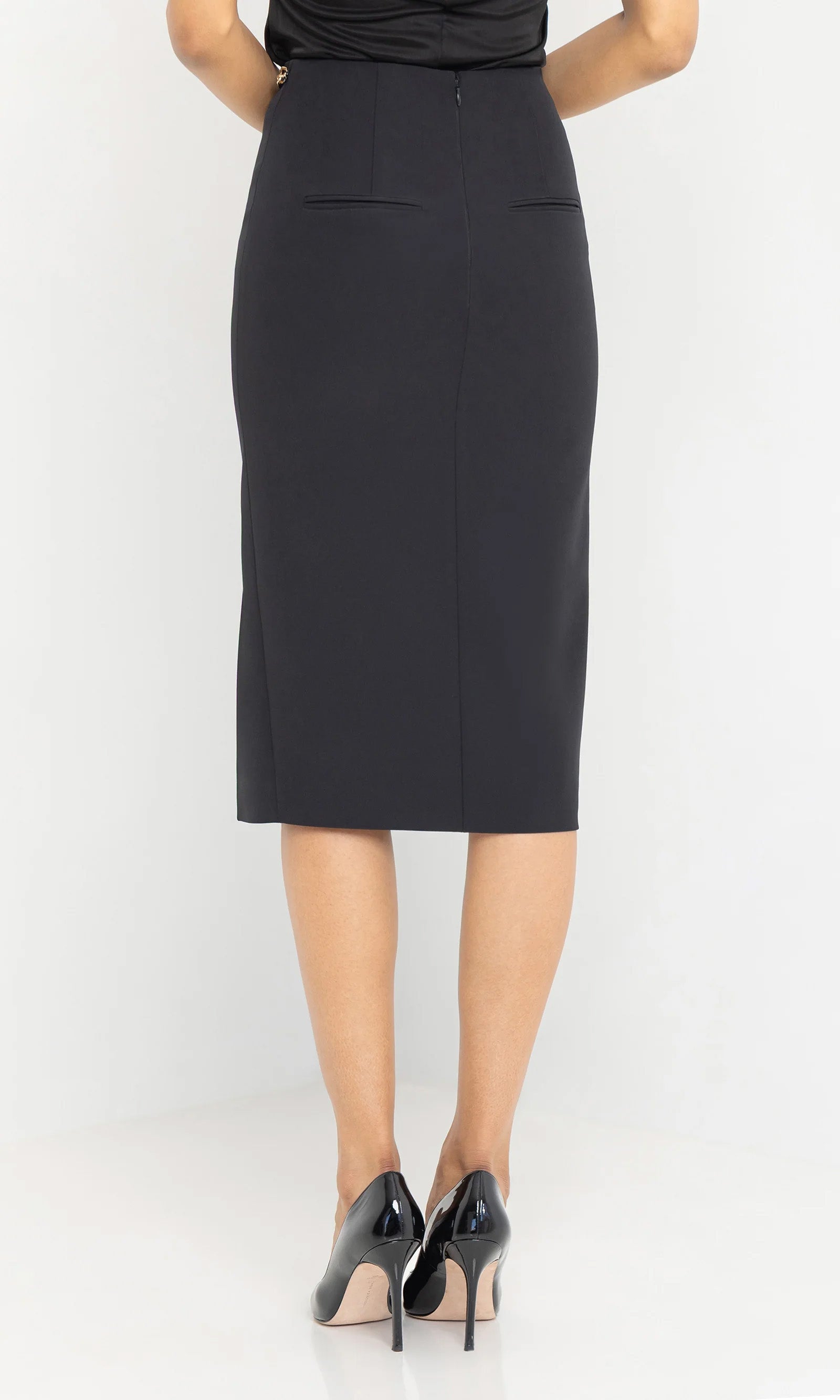 model standing backwards wearing long skirt and black heels
