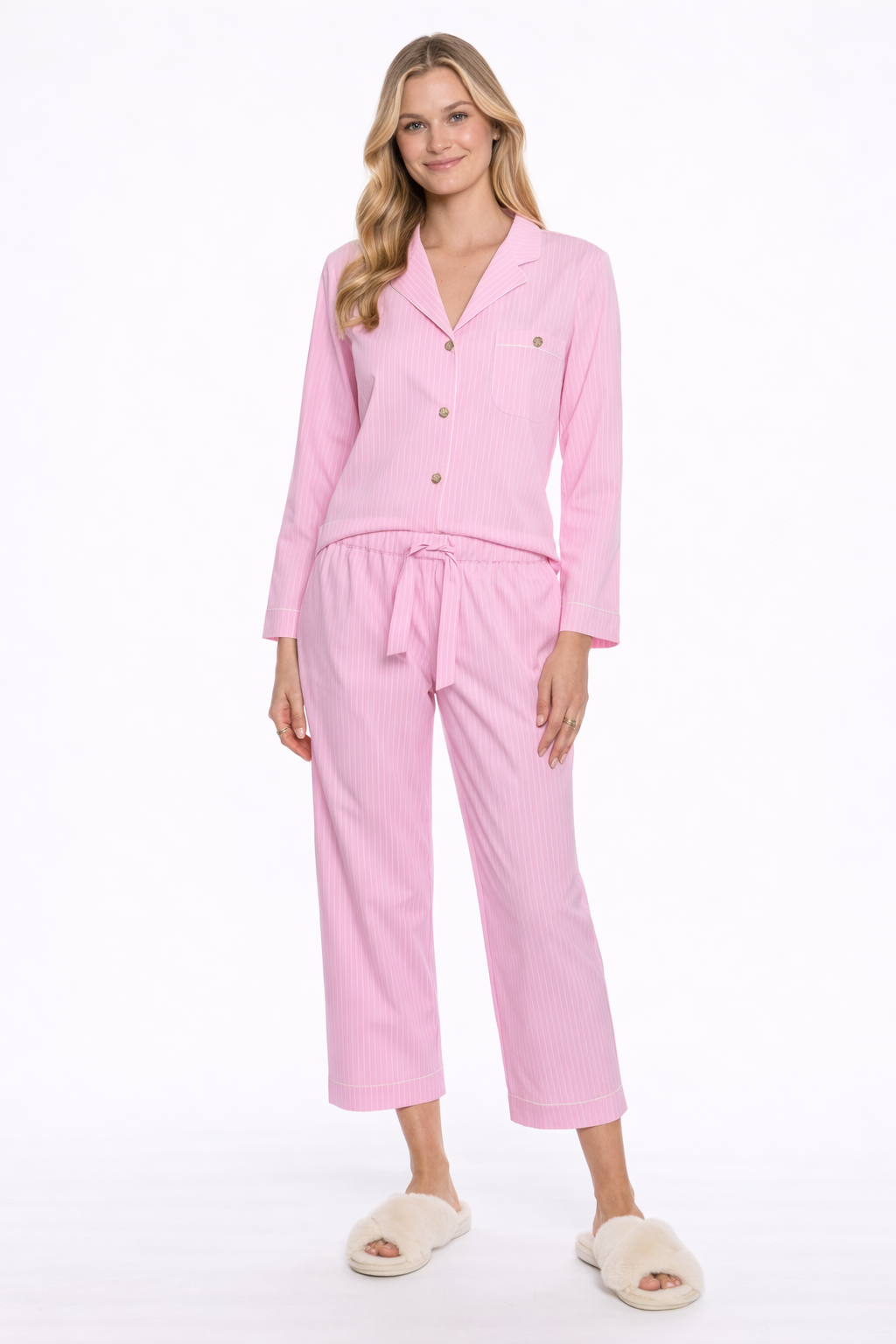 Full body image of woman wearing a pink pajama set on a white background