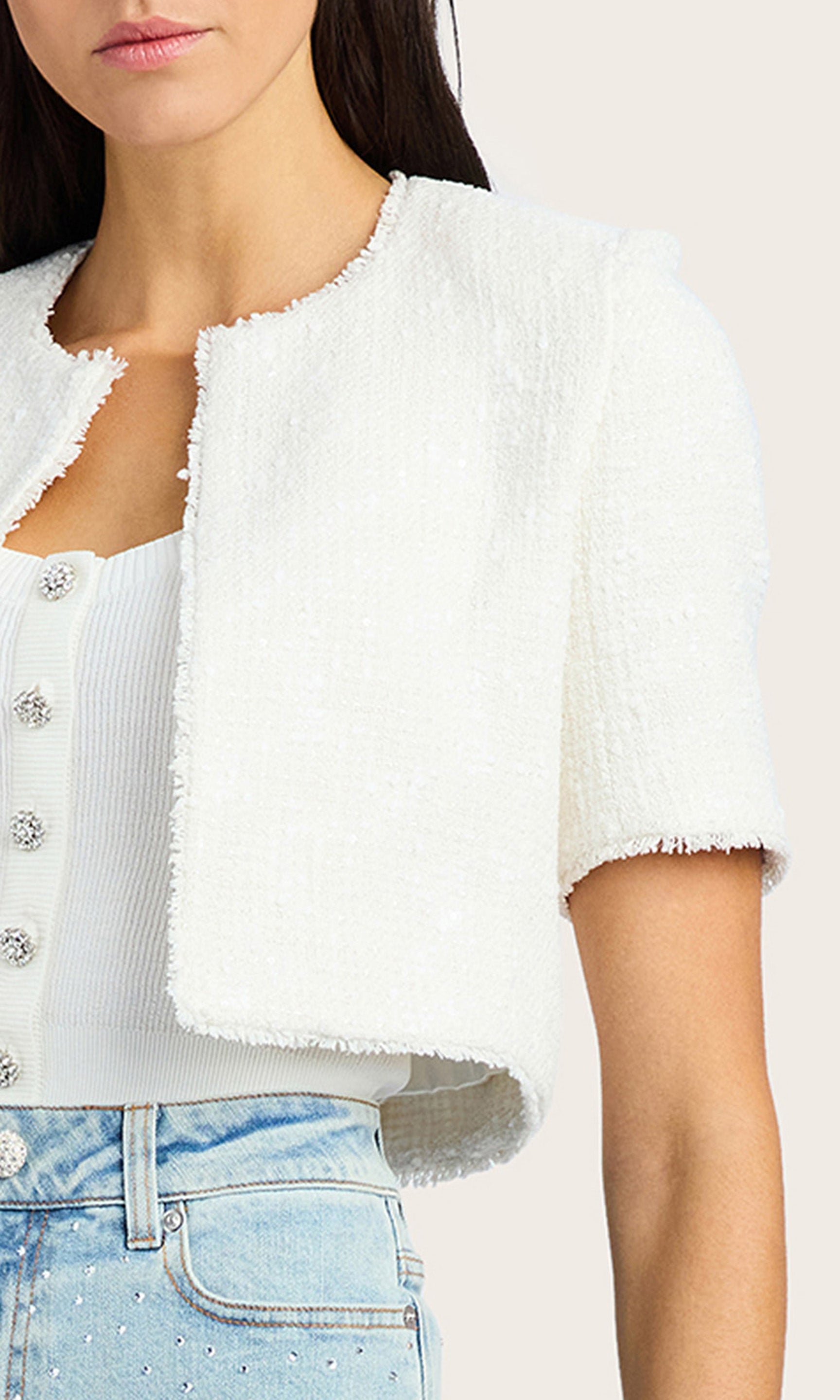 Zoomed in detail shot of the model wearing the Nikki Tweed Jacket in white with light denim shorts.