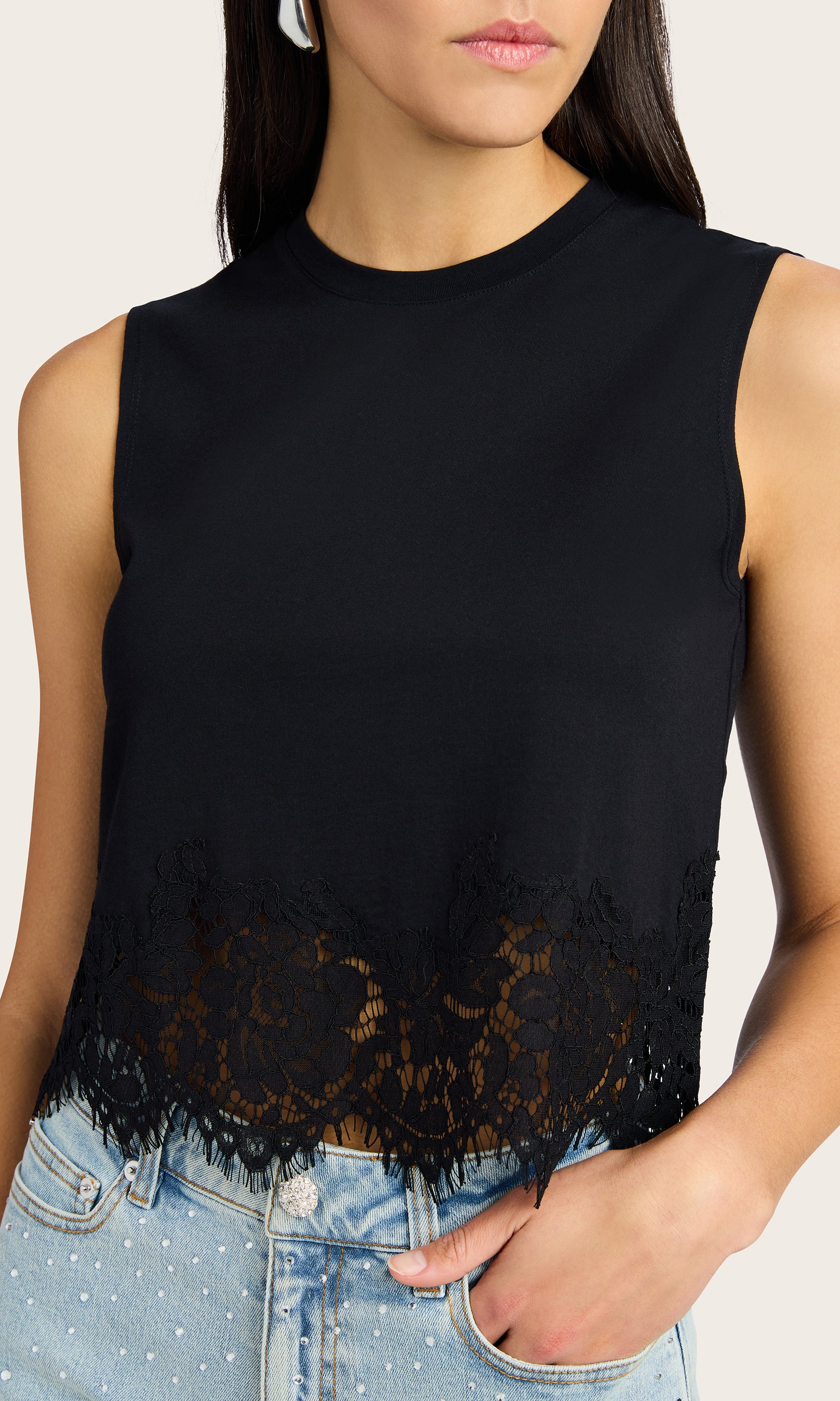 Zoomed in view of model wearing the Palani Lace Combo Top with black lace details on the hem, styled with denim shorts