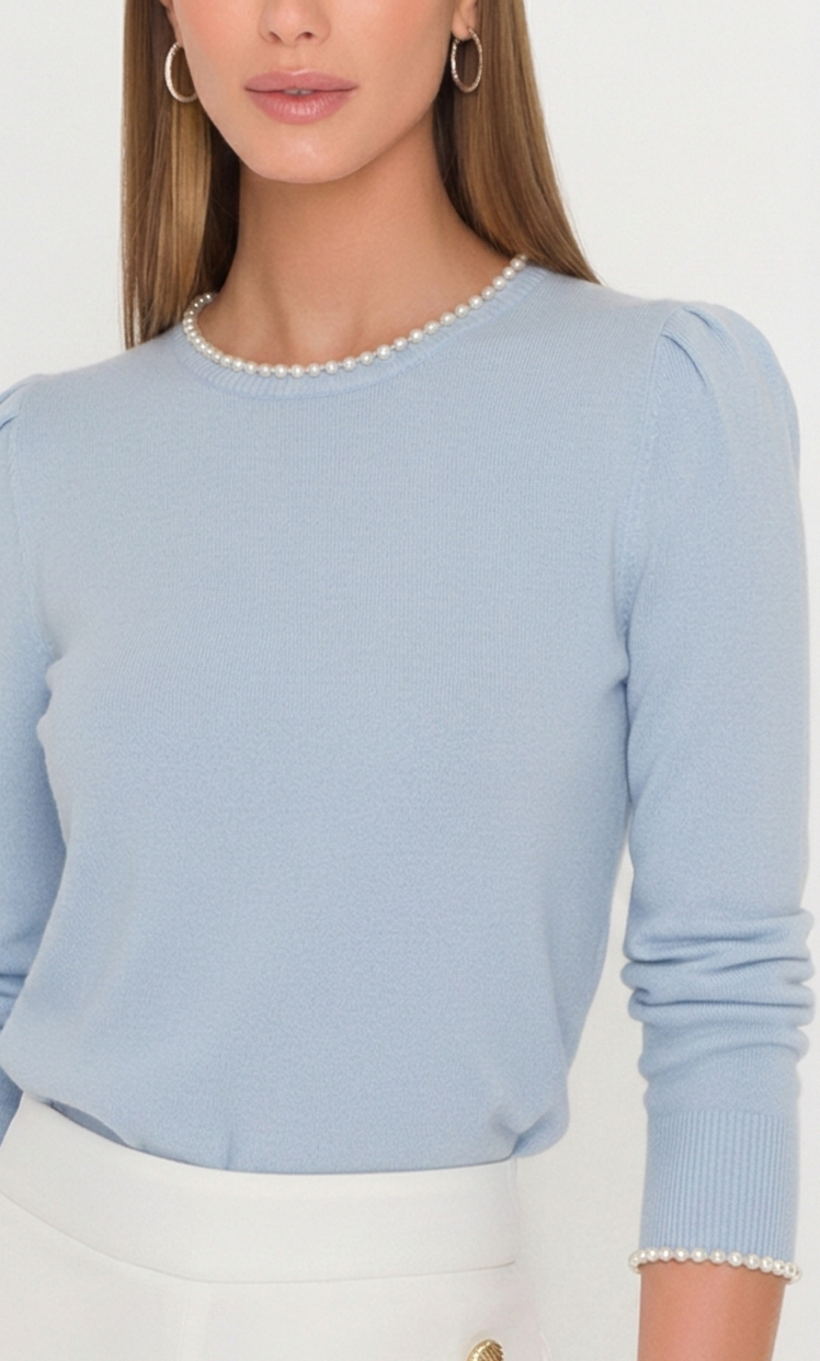 Light blue sweater with pearl trim worn by a person on a white background