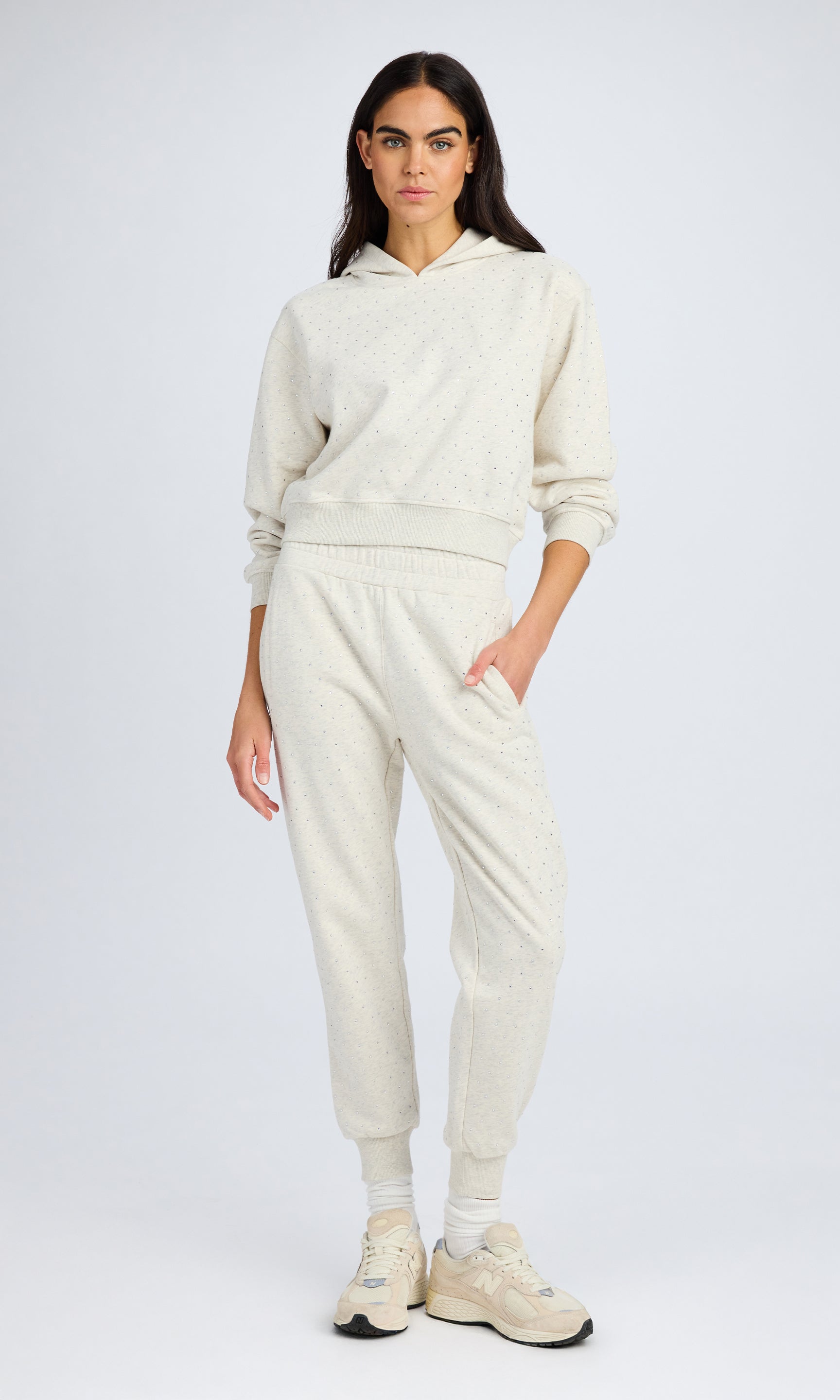 Model stands wearing a heather grey crystal sweatshirt and matching sweatpants.