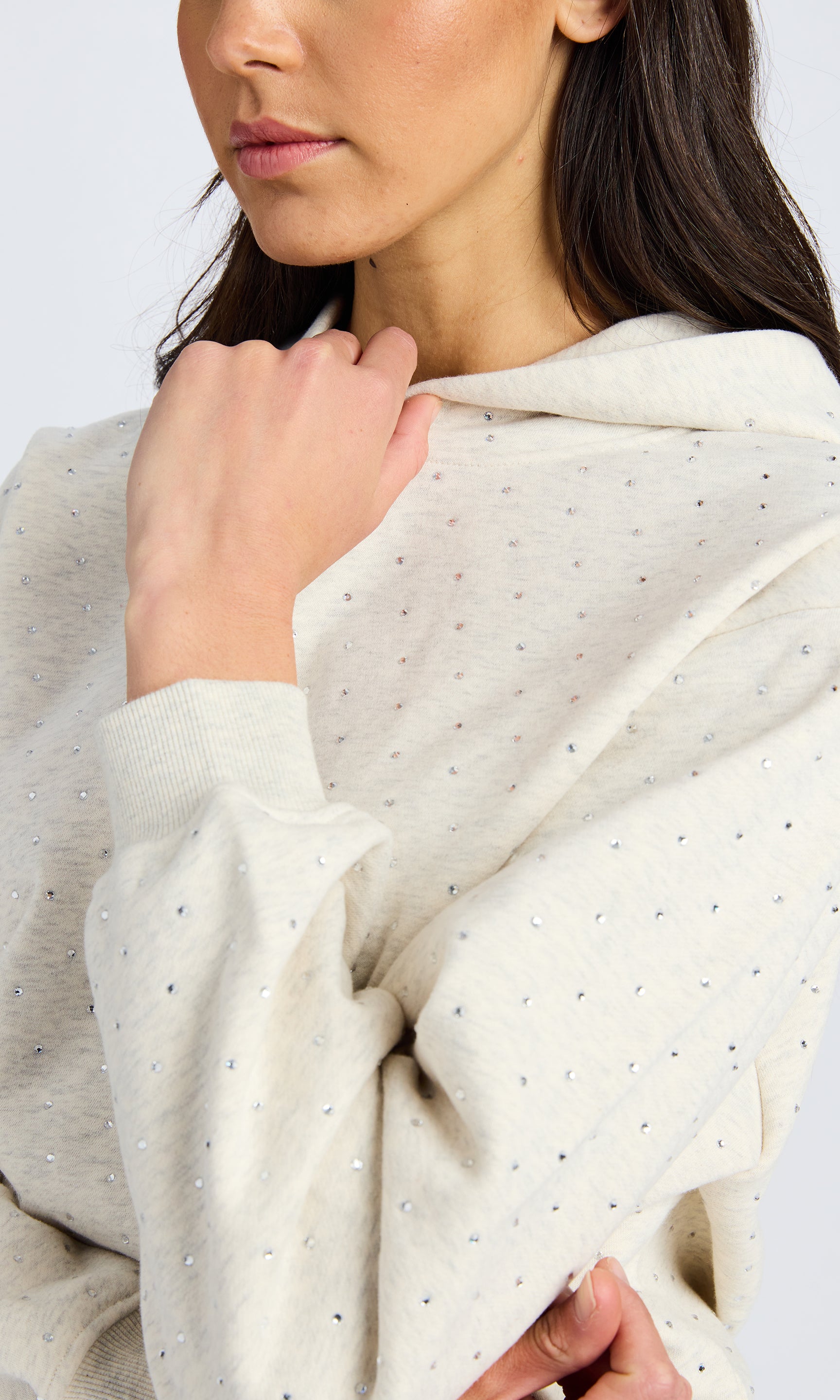 Close up image of a heather grey hooded sweatshirt with crystals.