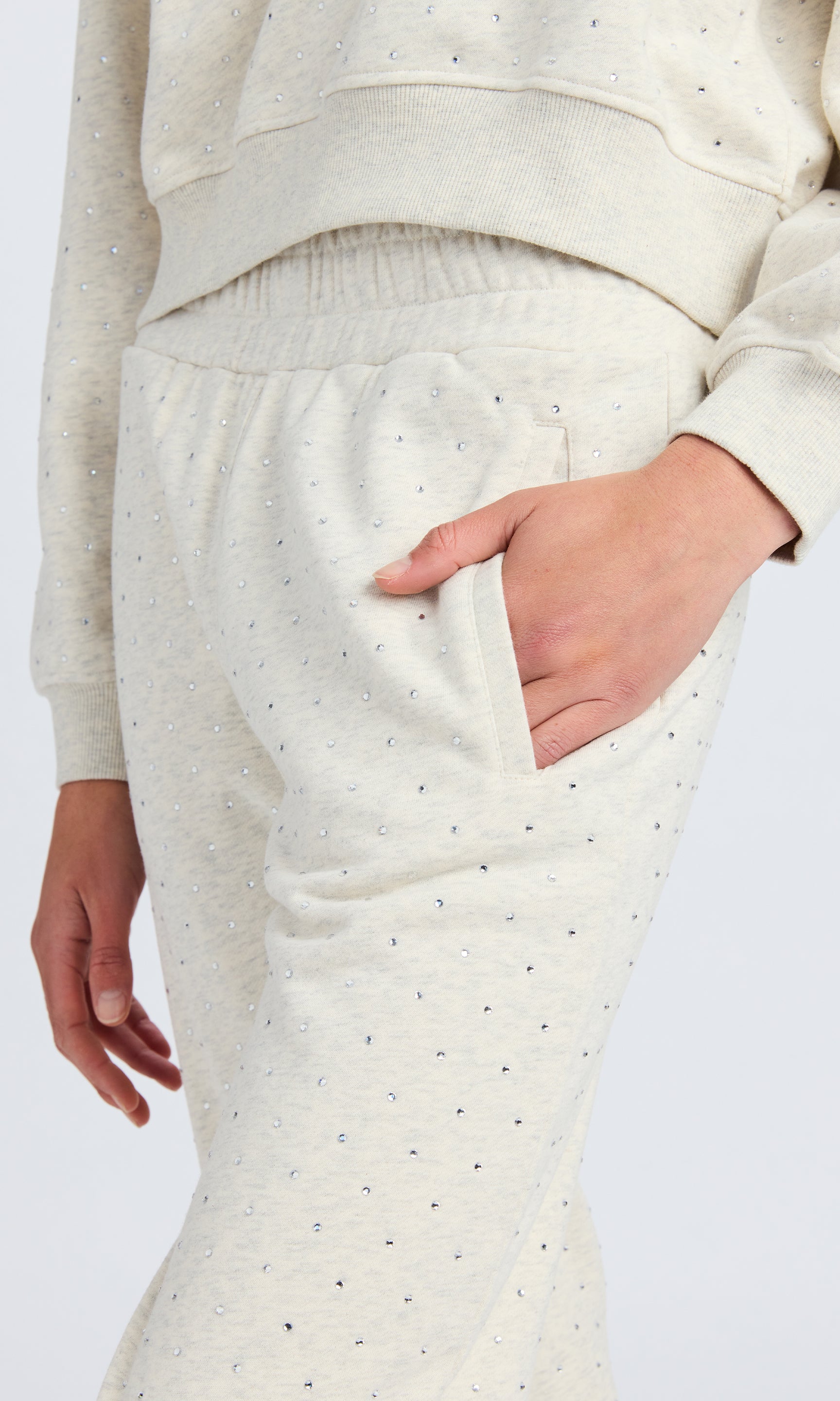 Detailed image of light grey sweatpants with close up on crystals.