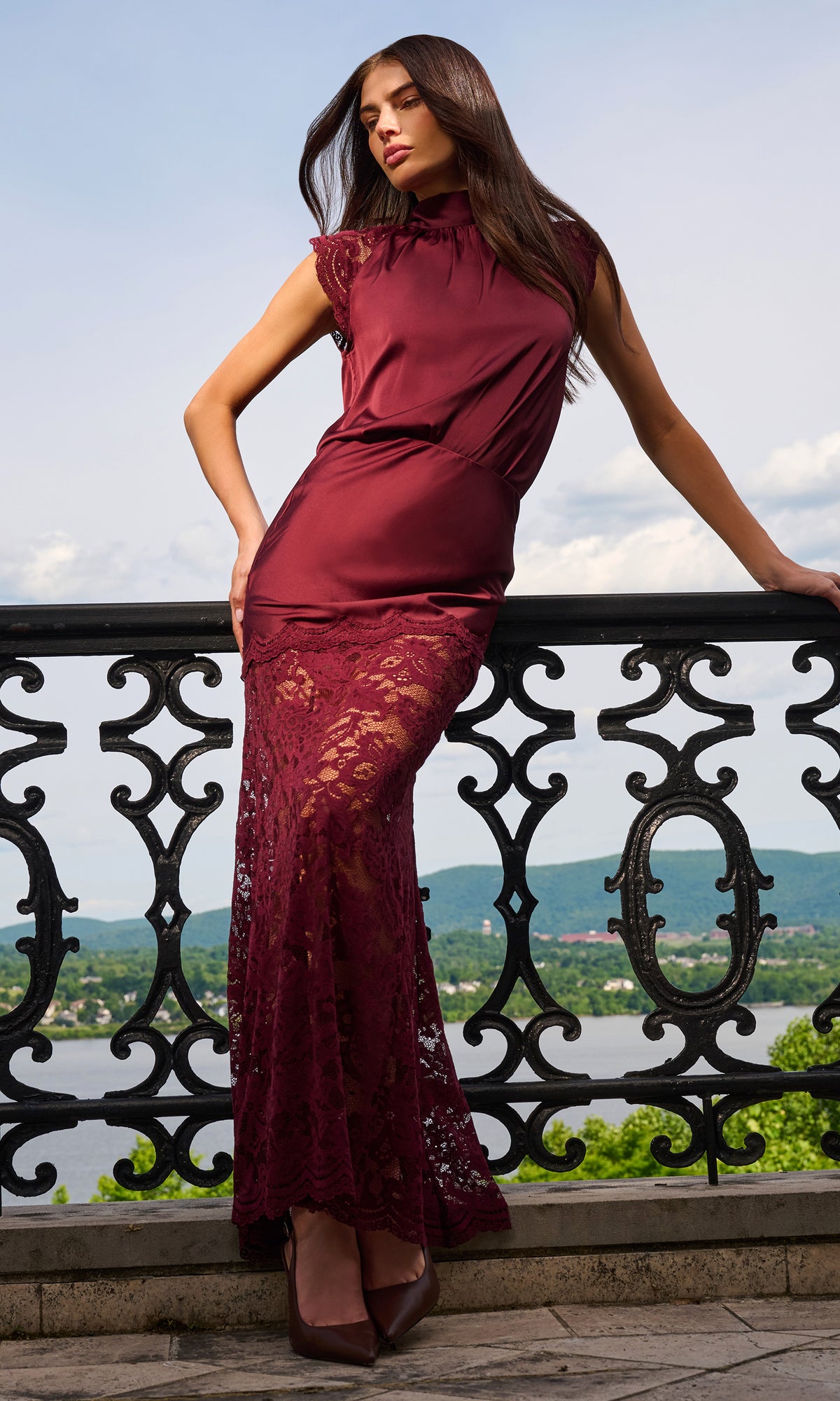 Model wearing a sleeveless high-neck blouse with a matching maxi skirt in deep burgundy.