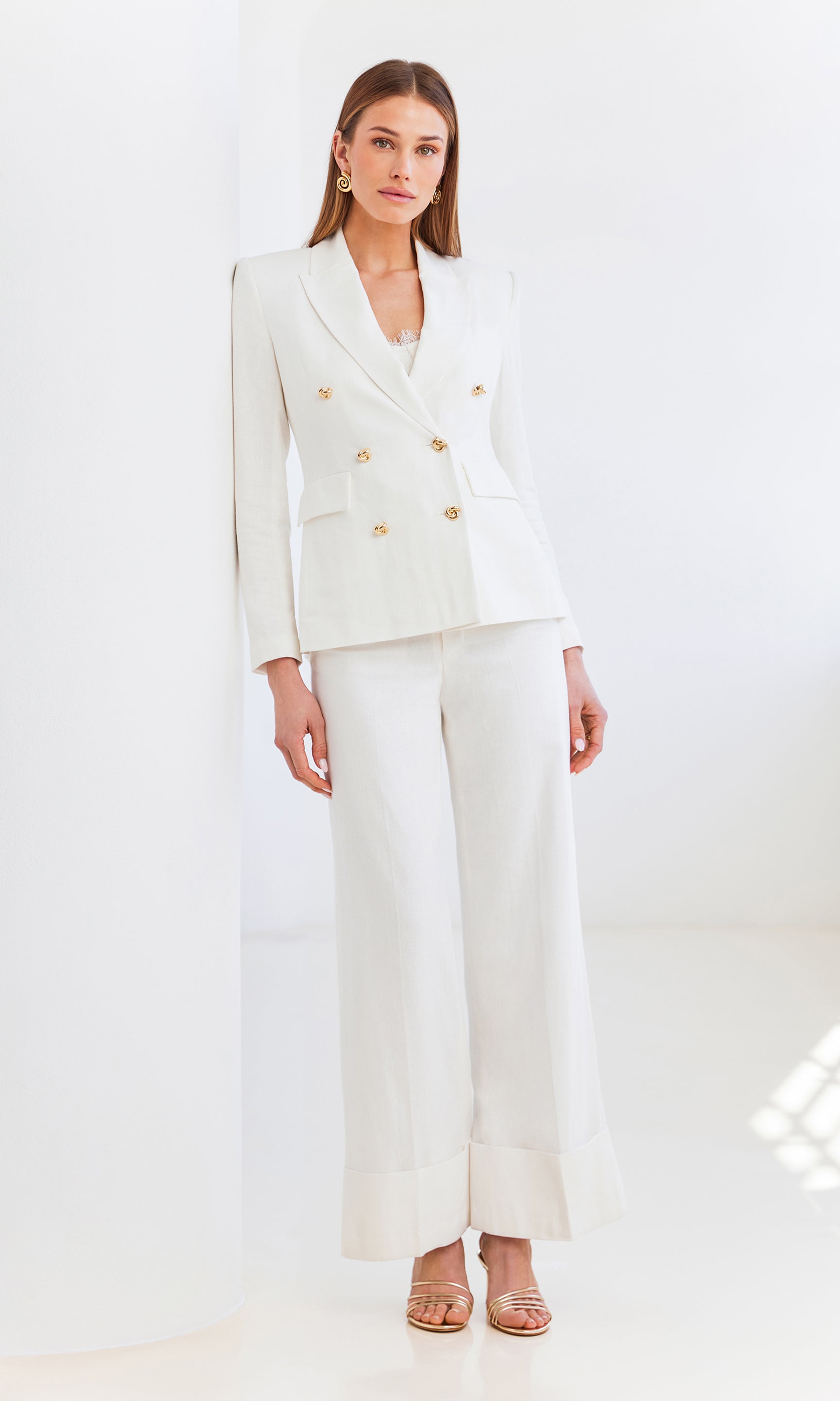 Editorial full body shot of the Raquel Linen Pants paired with a white blazer, styled for an easy yet polished seasonal look.