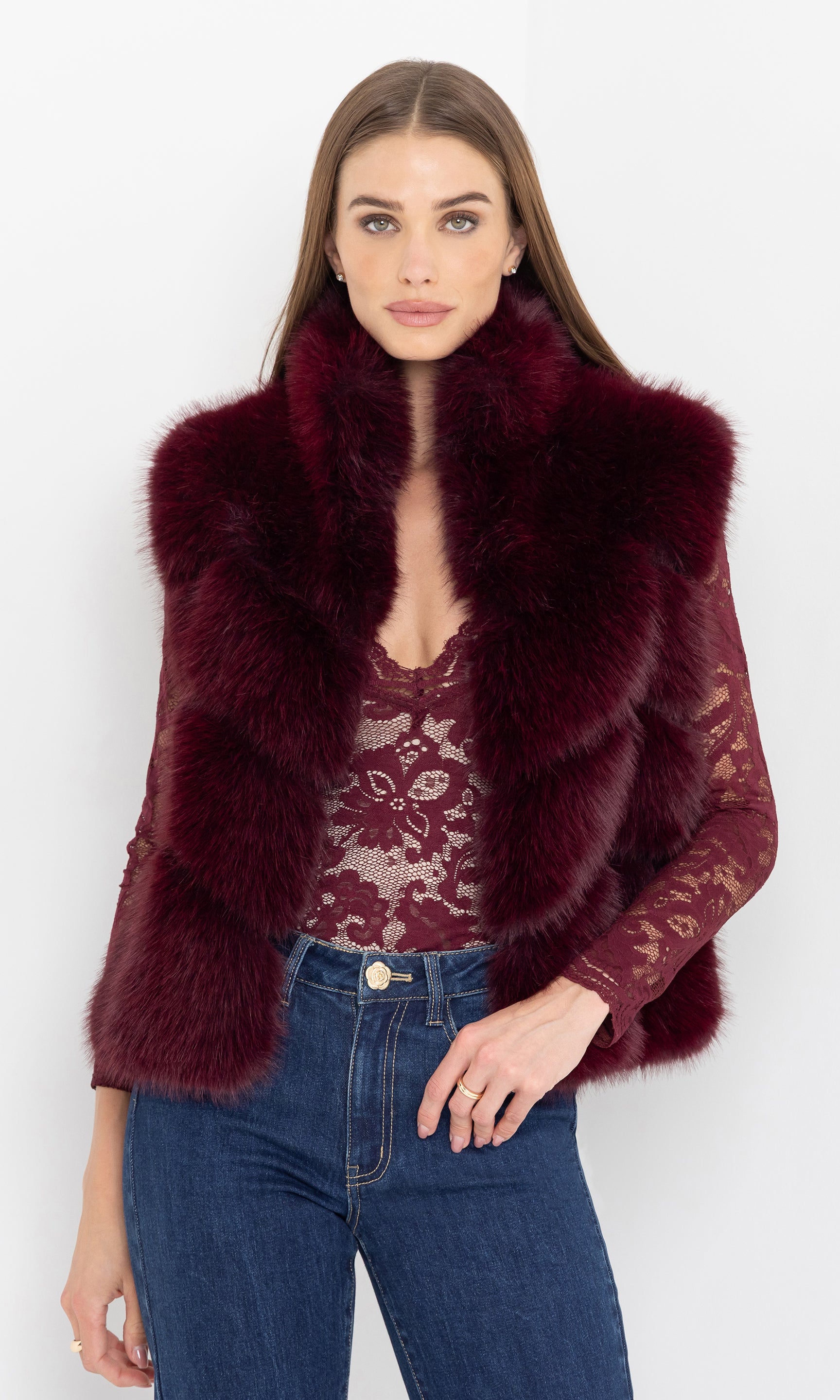 Model facing forward wearing the rosario faux fur vest styled with lace top and jeans.