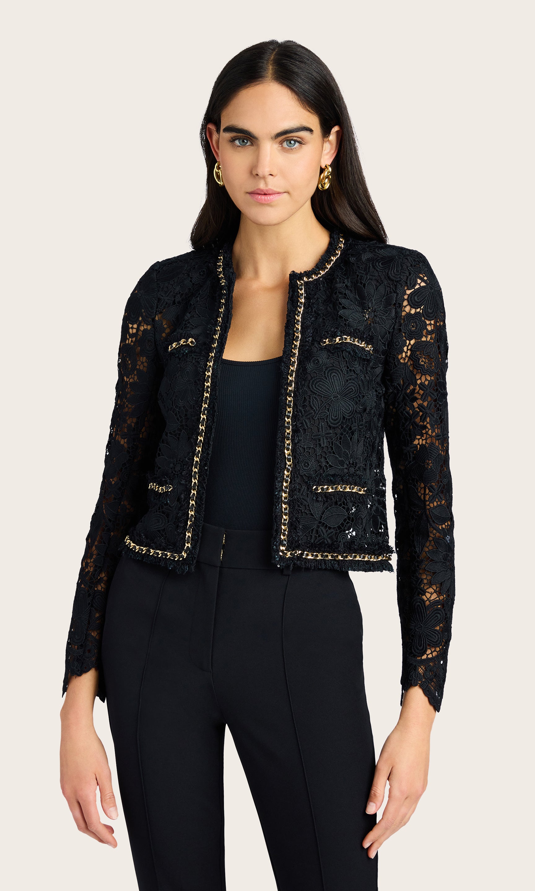 Front-facing studio view of the model in the black lace jacket showing the gold-trimmed neckline and slim silhouette
