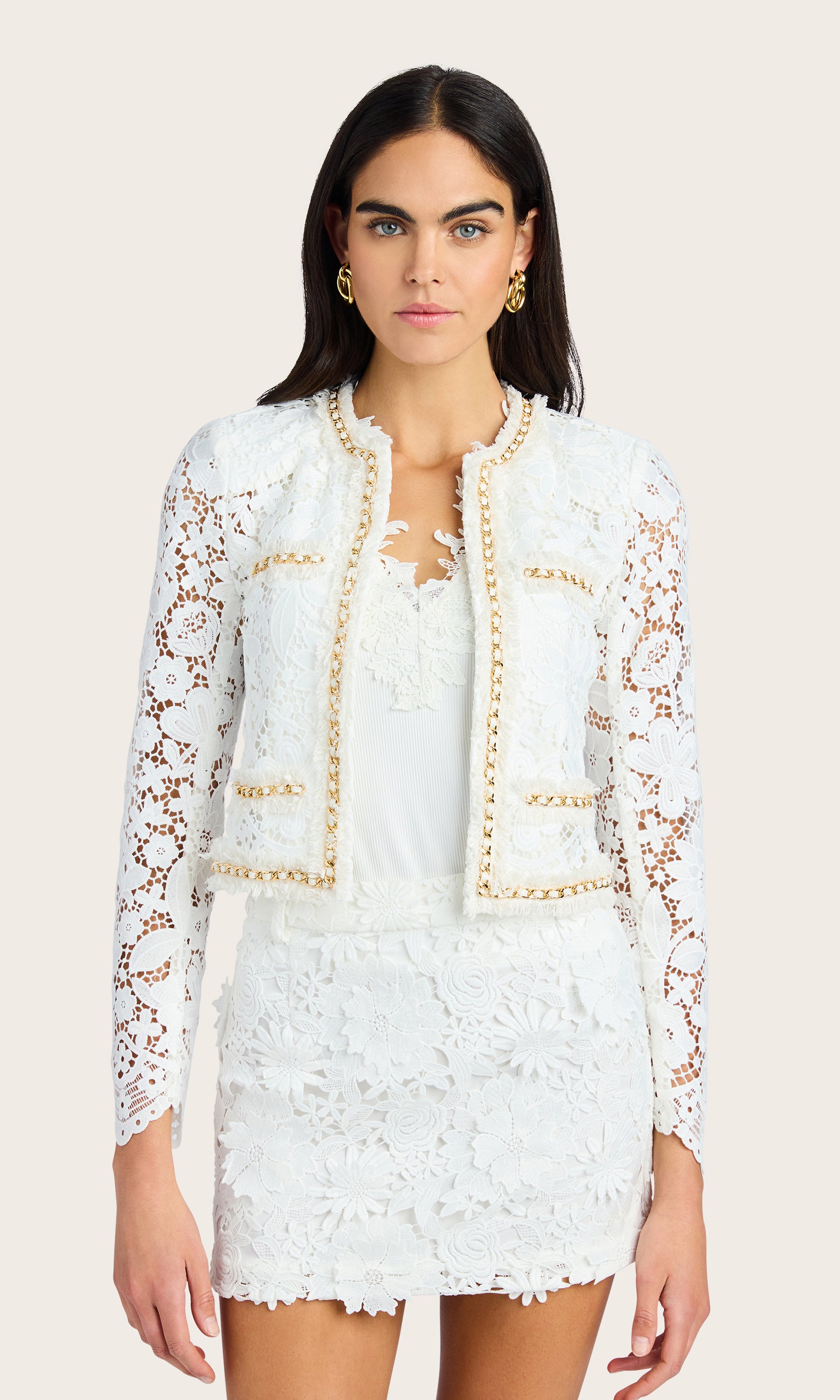 Front-facing studio view of the model wearing the white lace blazer and matching mini skirt