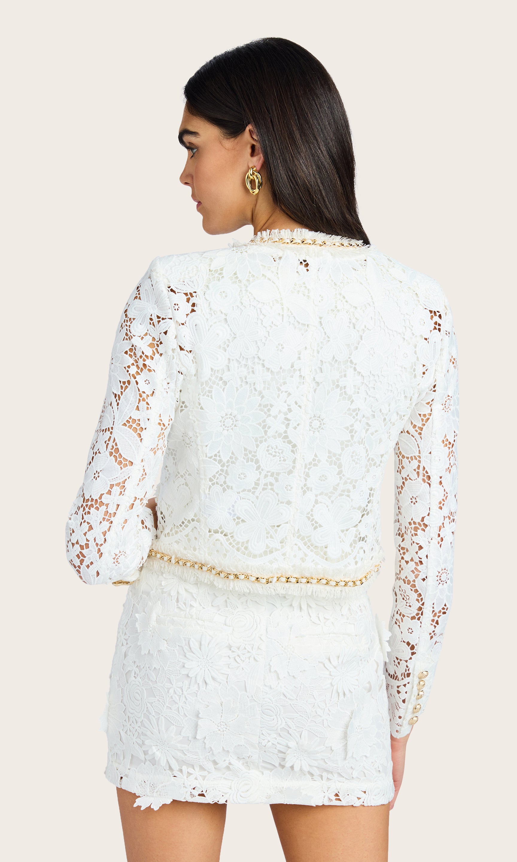Rear-facing view displaying the lace pattern and structured cut of the white blazer