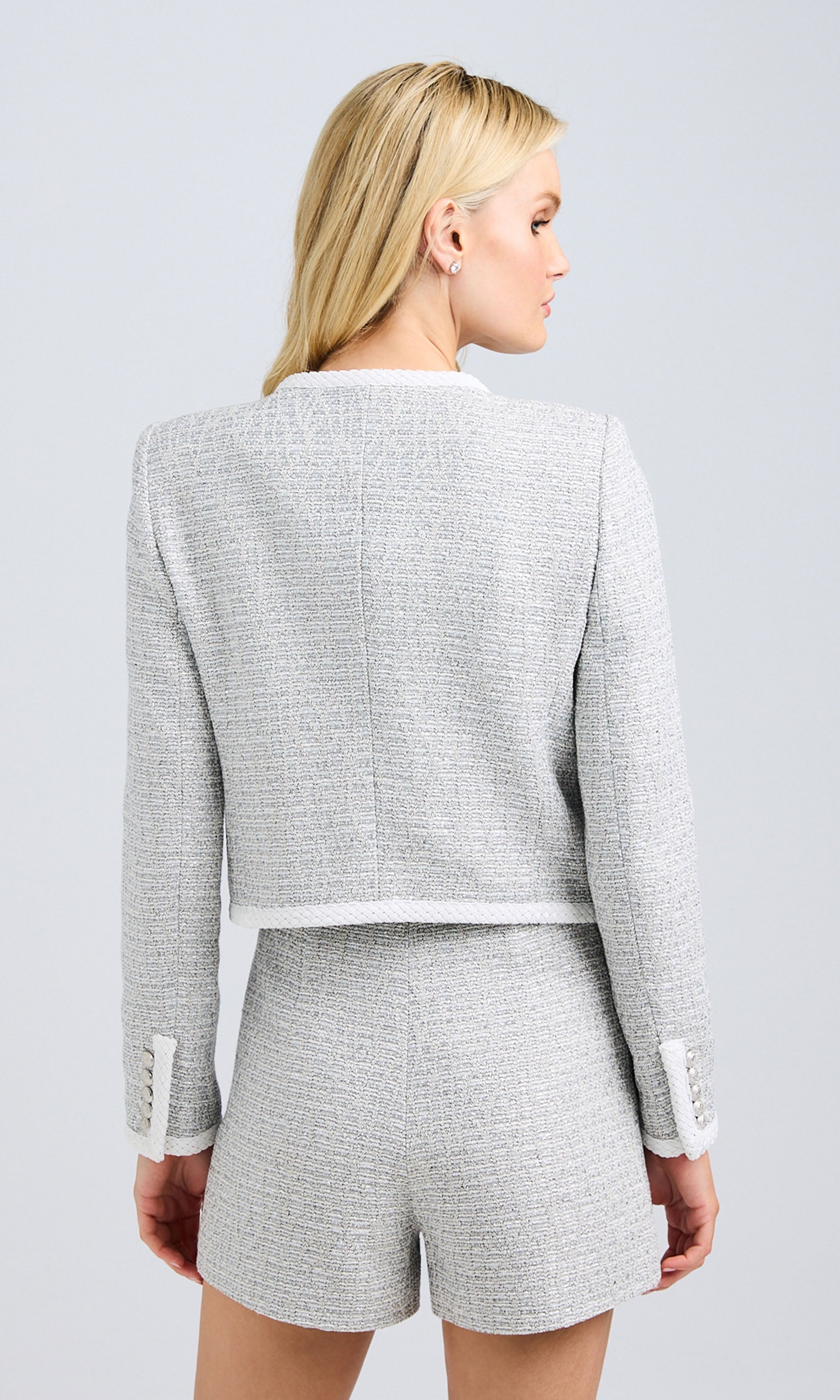 Rear view highlighting the back details of the jacket and shorts, emphasizing the tailored fit and clean lines.
