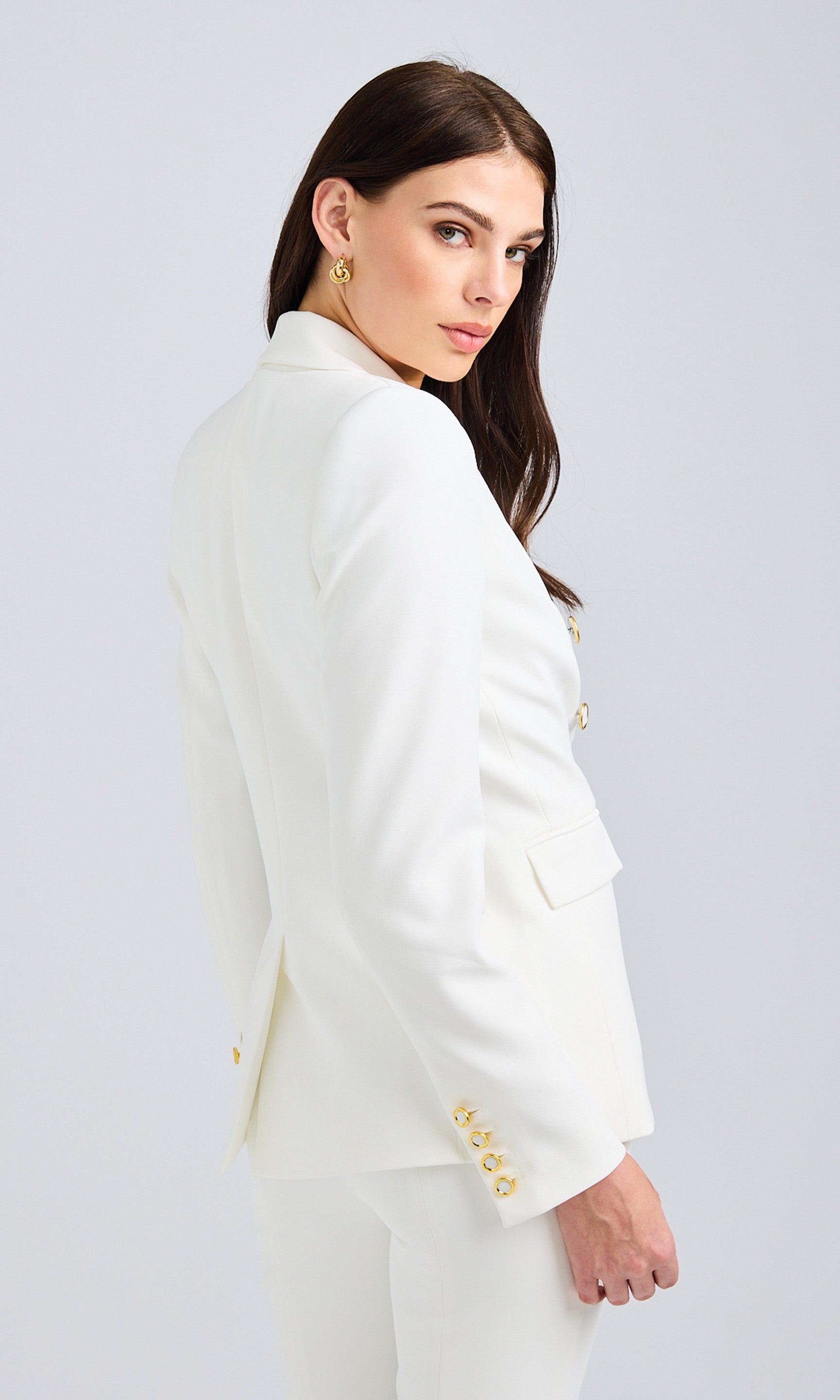 Rear view of the white blazer, showcasing the structured fit and back vent detail