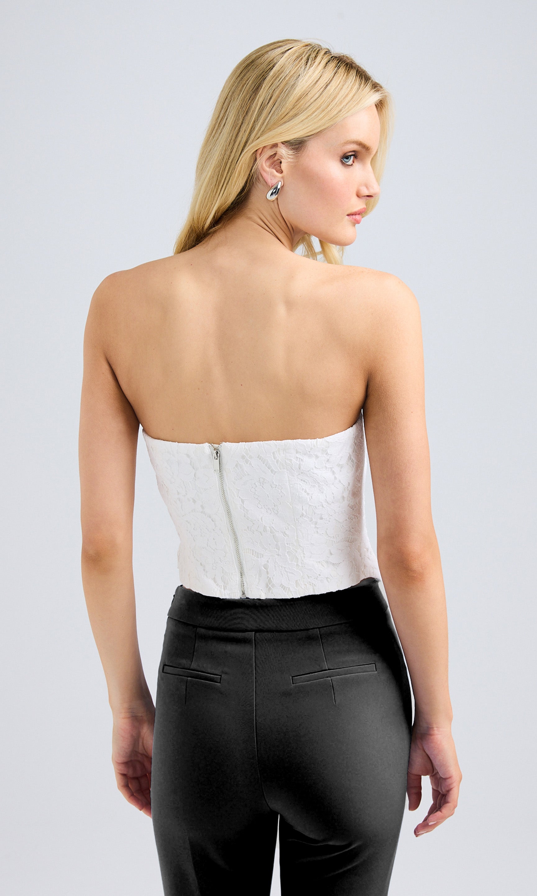 Back view of the white lace vestier, featuring a smooth design for a tailored fit.