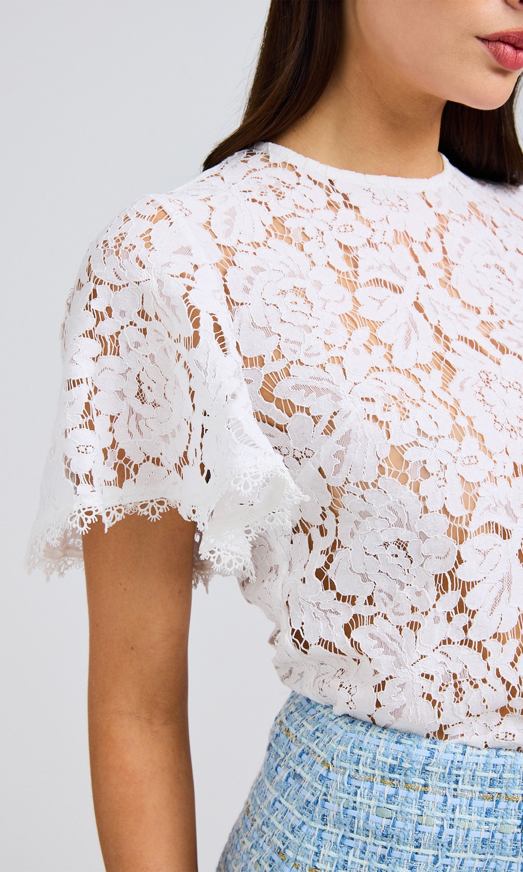 Close-up detail capturing the lace fabric, flutter sleeves, and delicate texture.