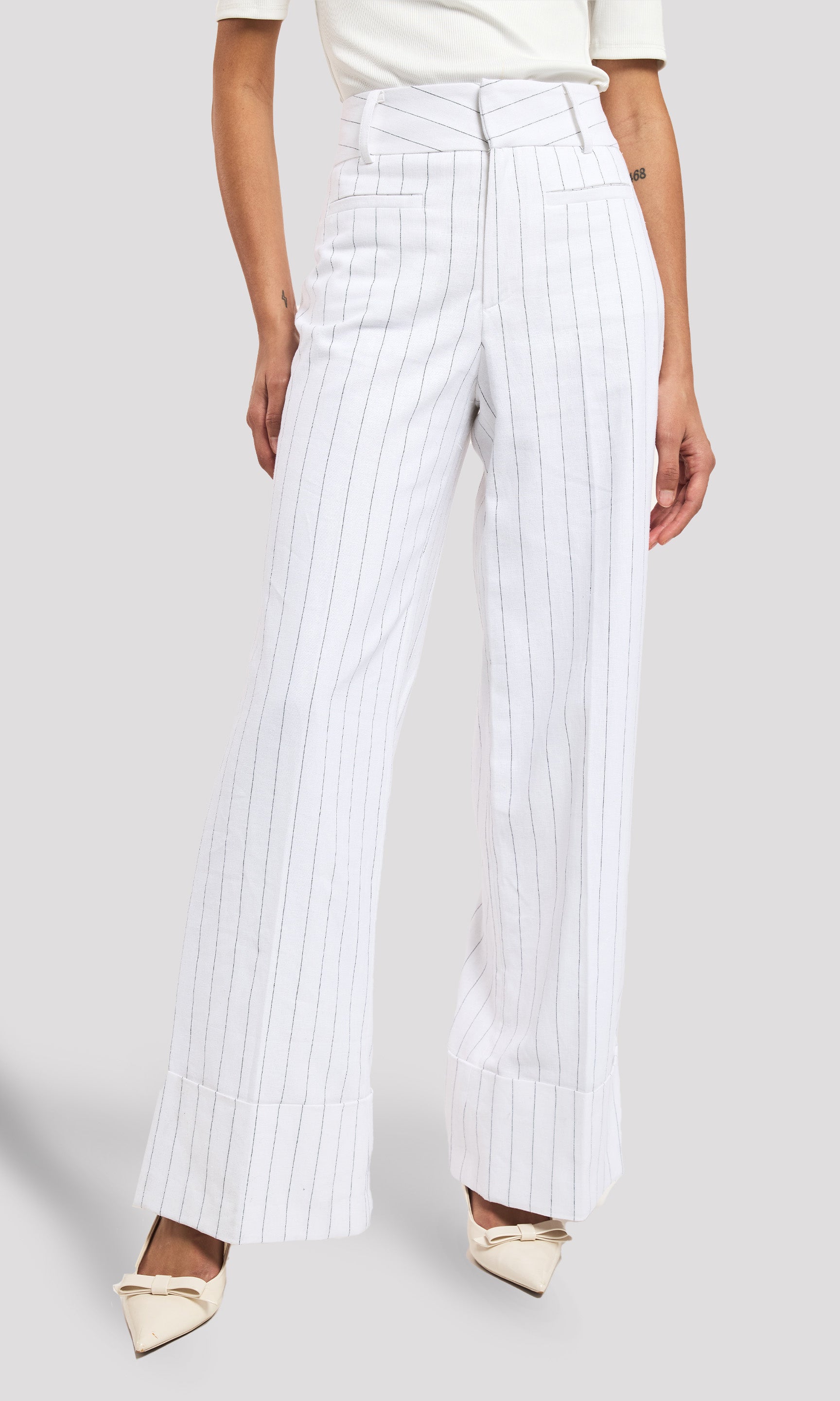 White pinstripe pants worn by a person on a white background