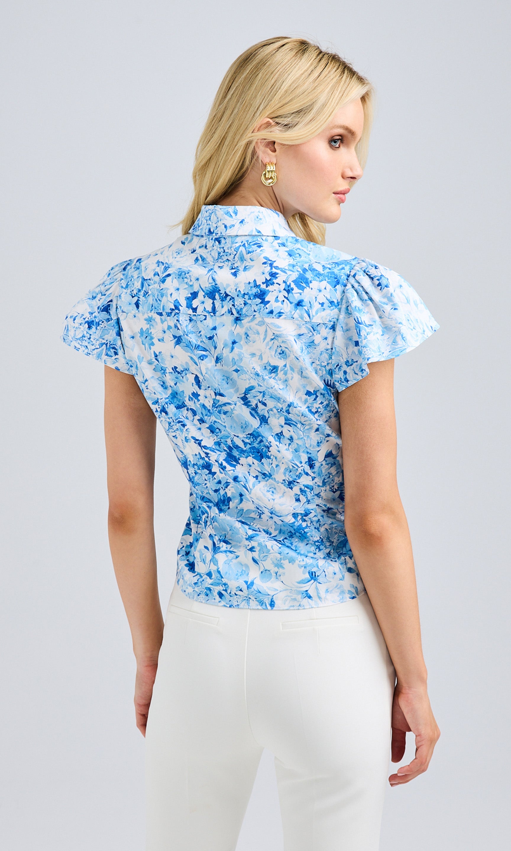 Rear view showcasing the tailored fit, flutter sleeve detail, and structured silhouette.