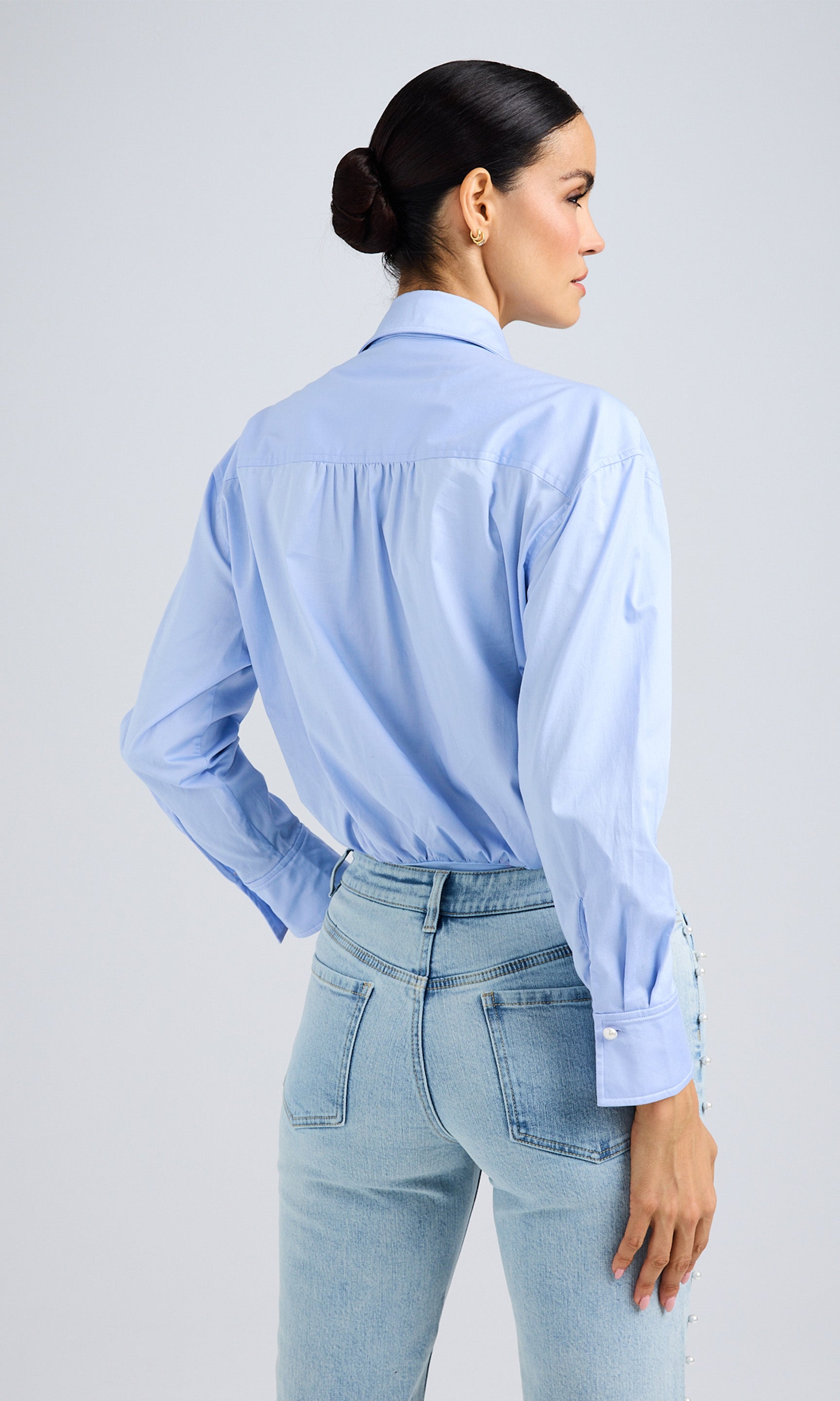Rear view of the shirt, showing the relaxed fit, back yoke detail, and cuffed sleeves.