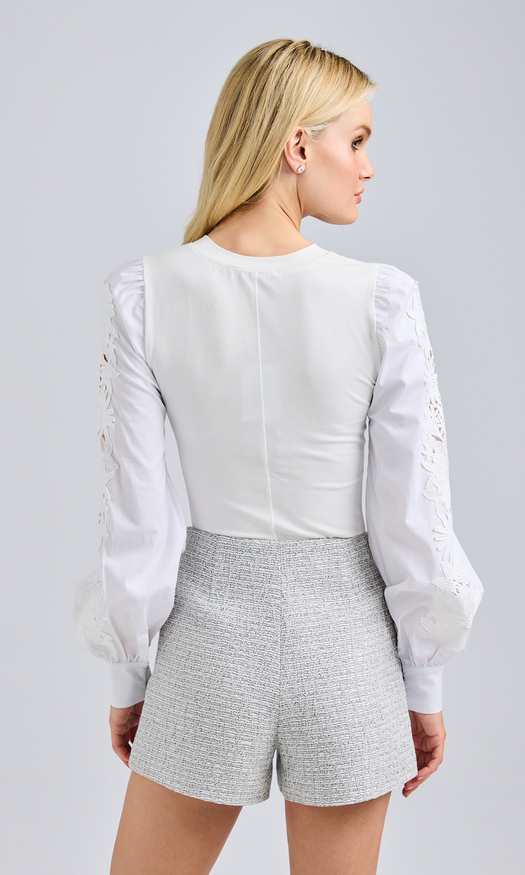 Rear view showcasing the blouse’s tailored fit and delicate lace sleeves.