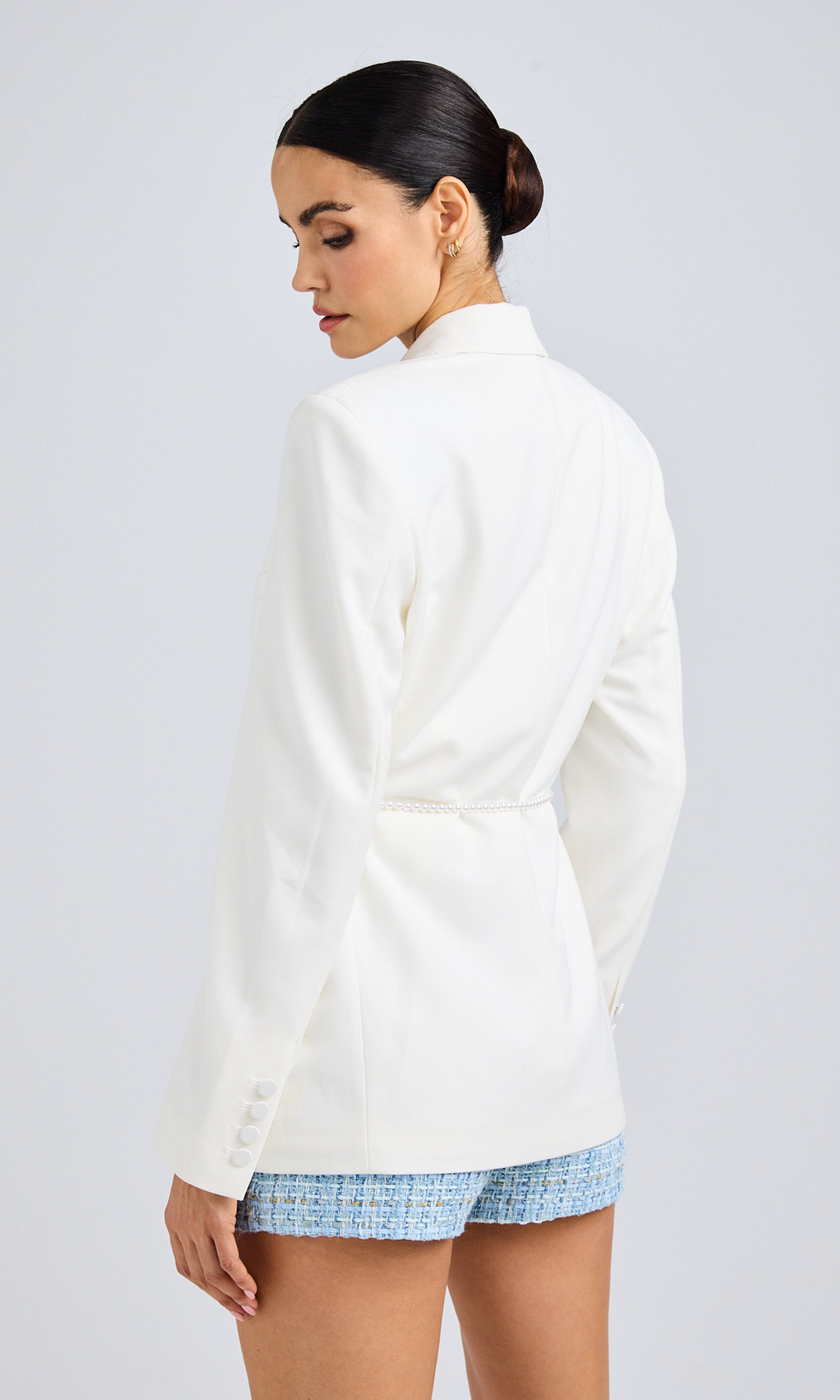 Back view of the white blazer, showcasing the tailored fit and sleek design.