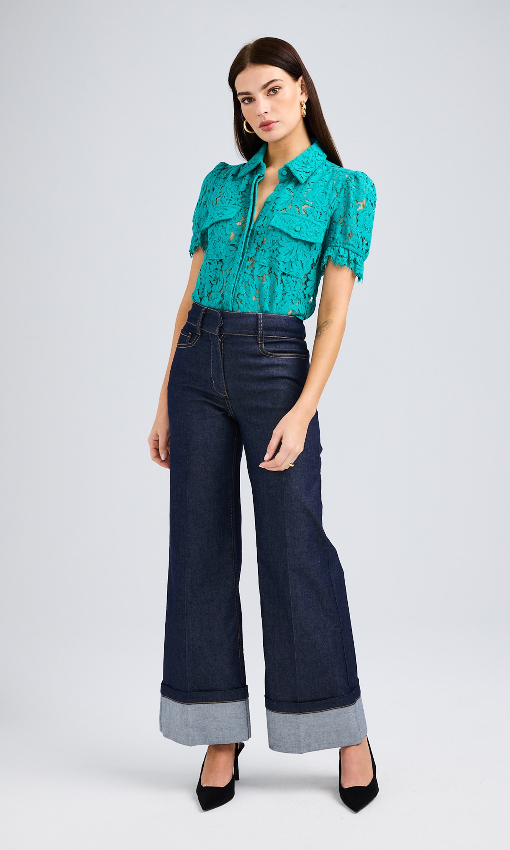 Dark-haired woman wearing a topaz button-up shirt with short sleeves and sheer lace.