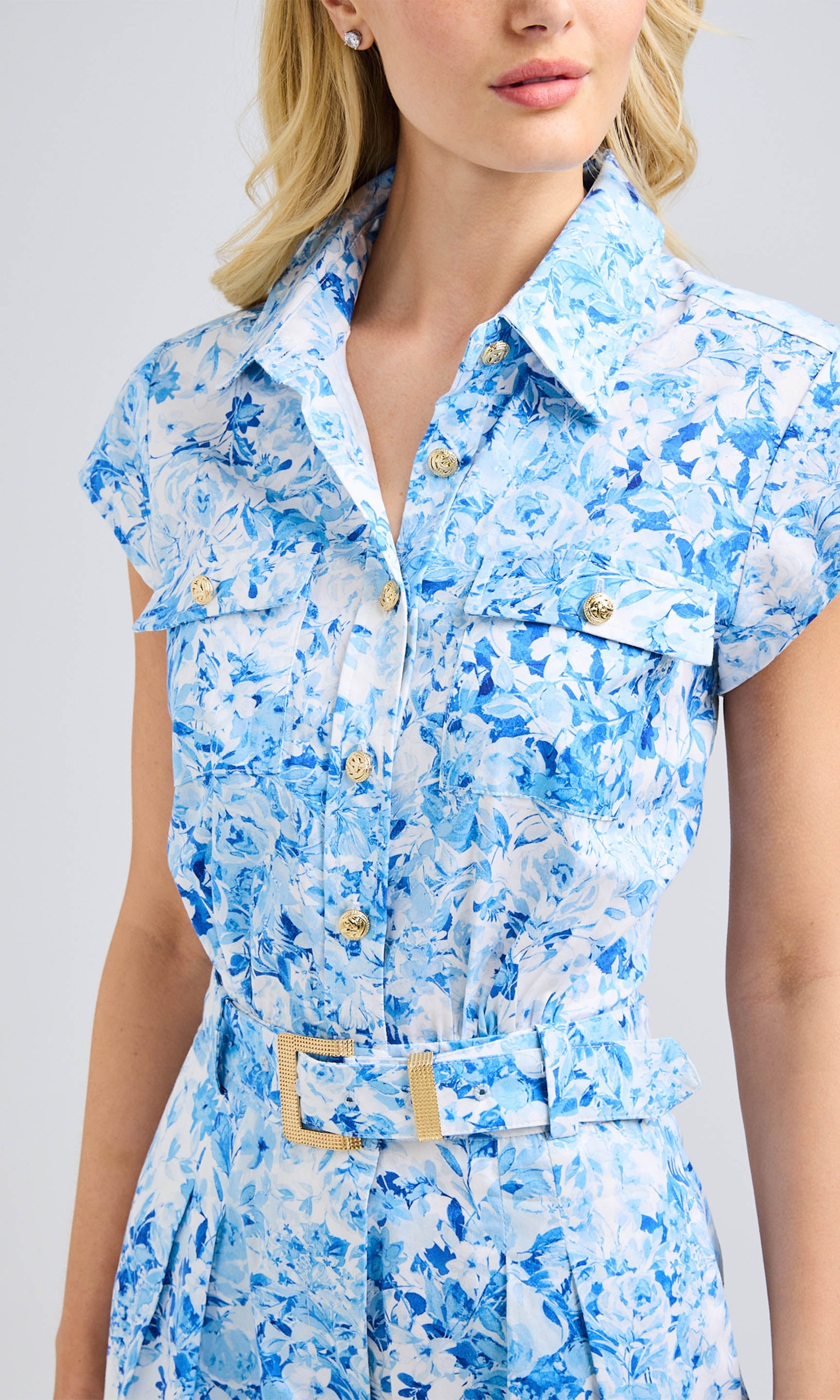 Close-up of blue floral romper highlighting the collared neckline and button details.